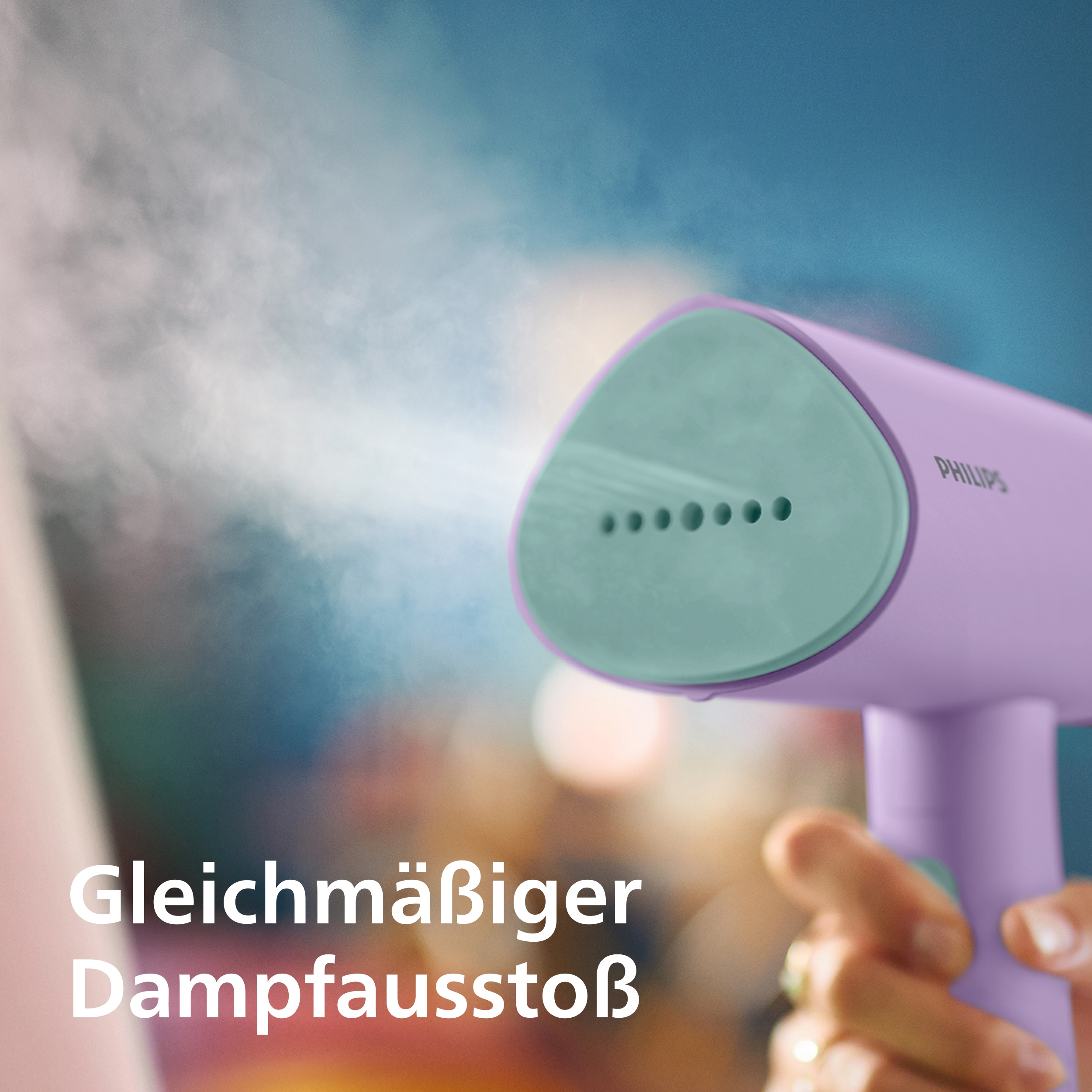 Lila Handdampfbügeleisen mit grünem Kopf sprüht Dampf
