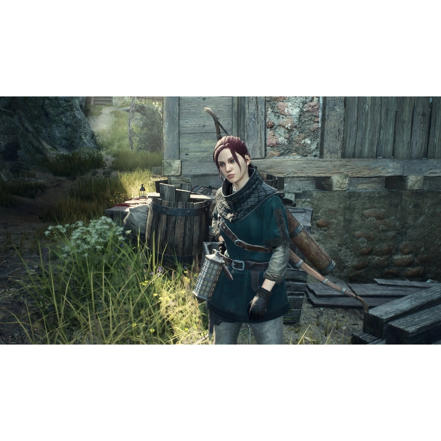 Une femme avec un arc et des flèches se tient dans une zone herbeuse devant des structures en bois.