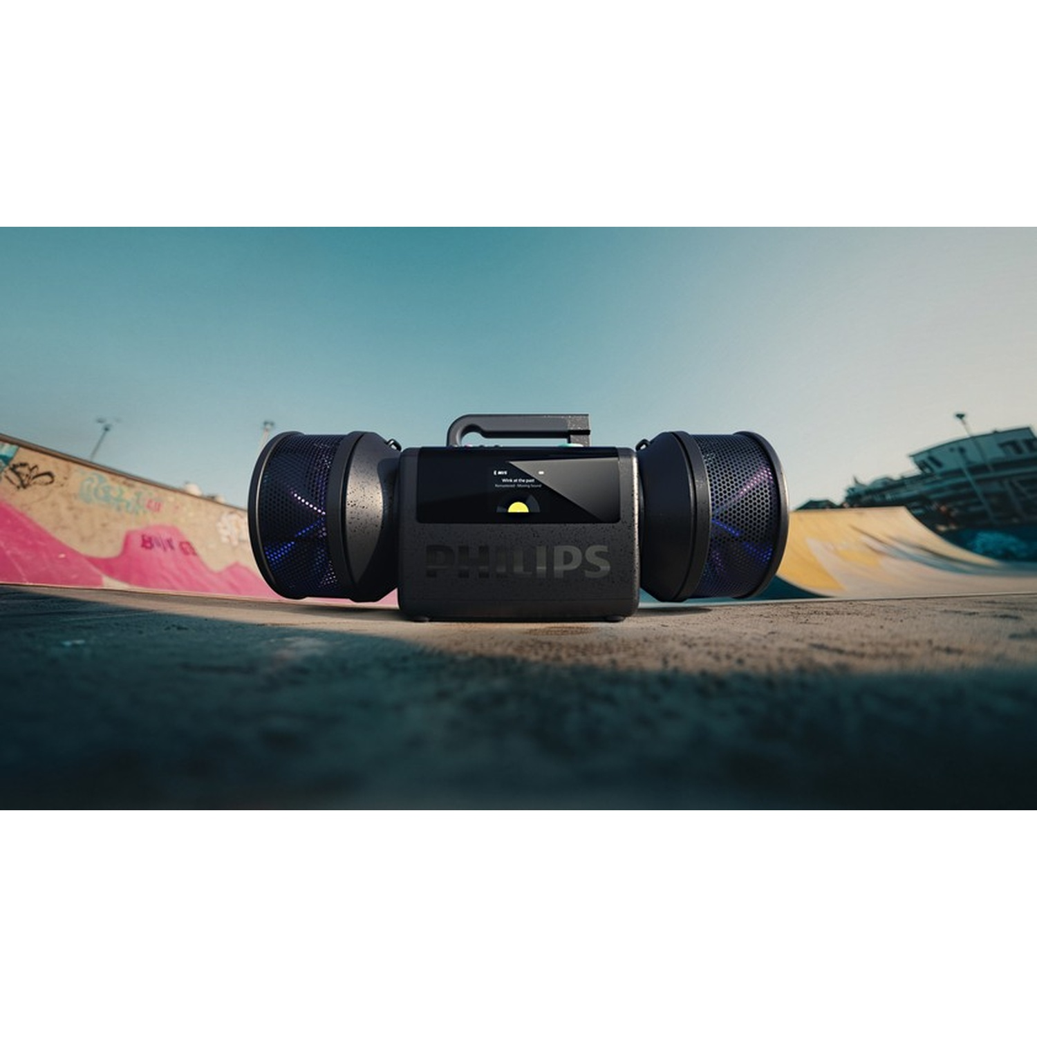 Altoparlante Philips nero con due grandi altoparlanti su terreno da skatepark.