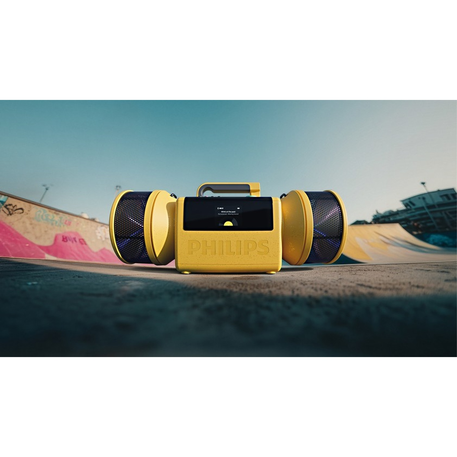 Un altoparlante Philips giallo è posato a terra in uno skatepark.