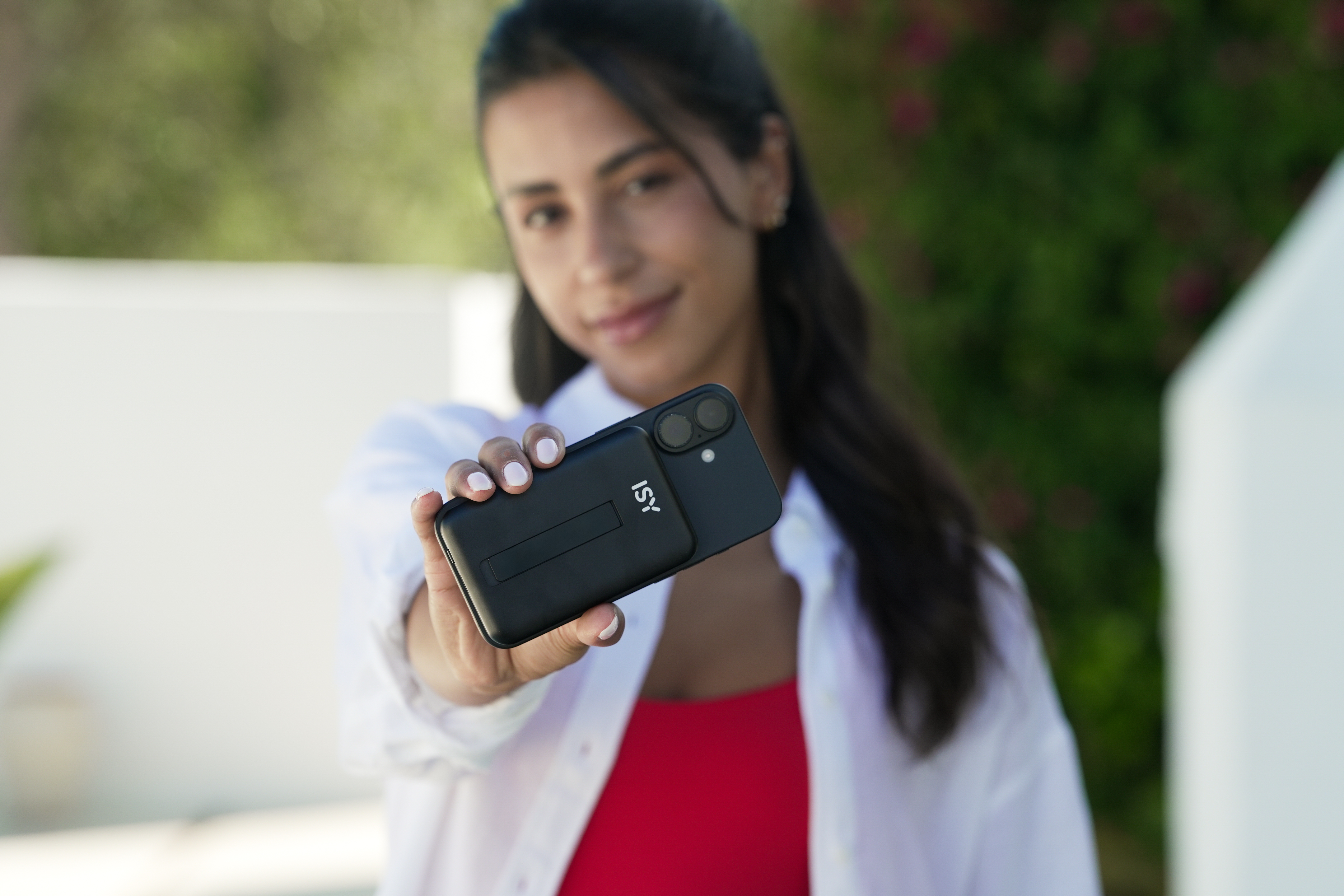 Eine Frau hält ein schwarzes Handy mit einer Powerbank und Ständer.