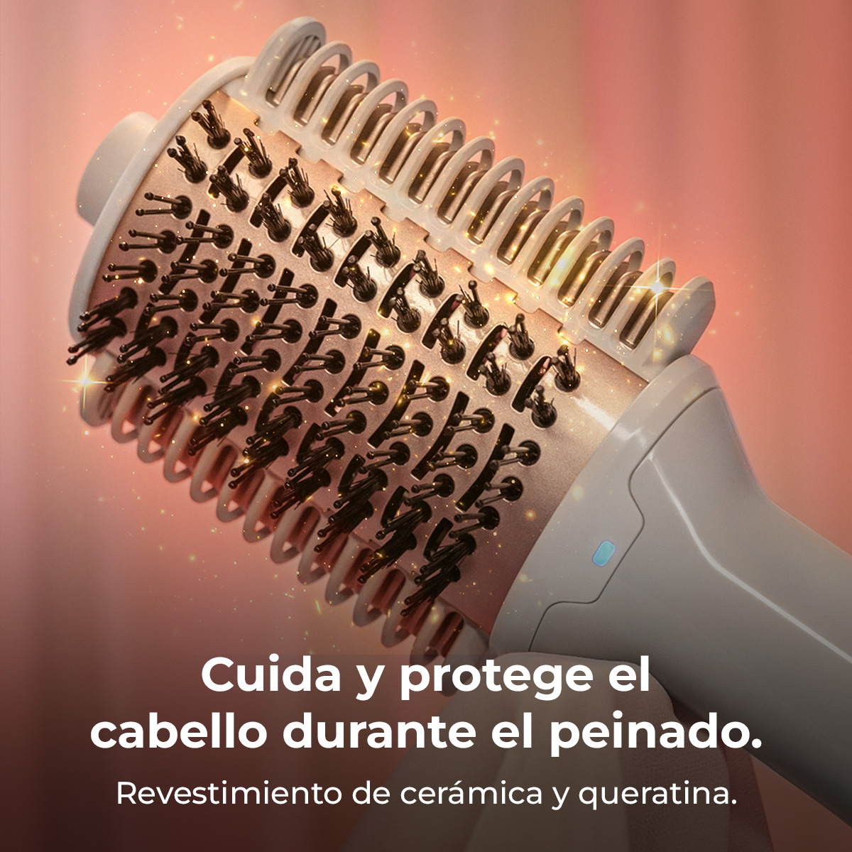 Un rizador con cerdas y revestimiento de cerámica y queratina sobre fondo rosa.