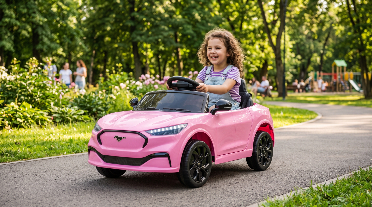 A girl drives a pink toy car on a park path, with trees and a playground in the background.