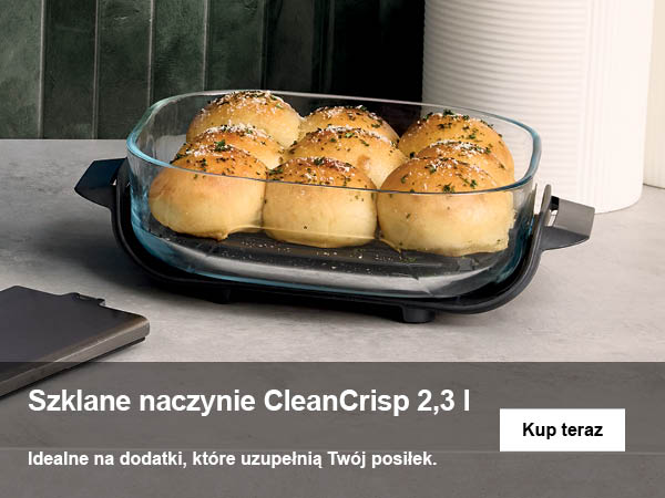Szklane naczynie z bułeczkami posypanymi ziołami.