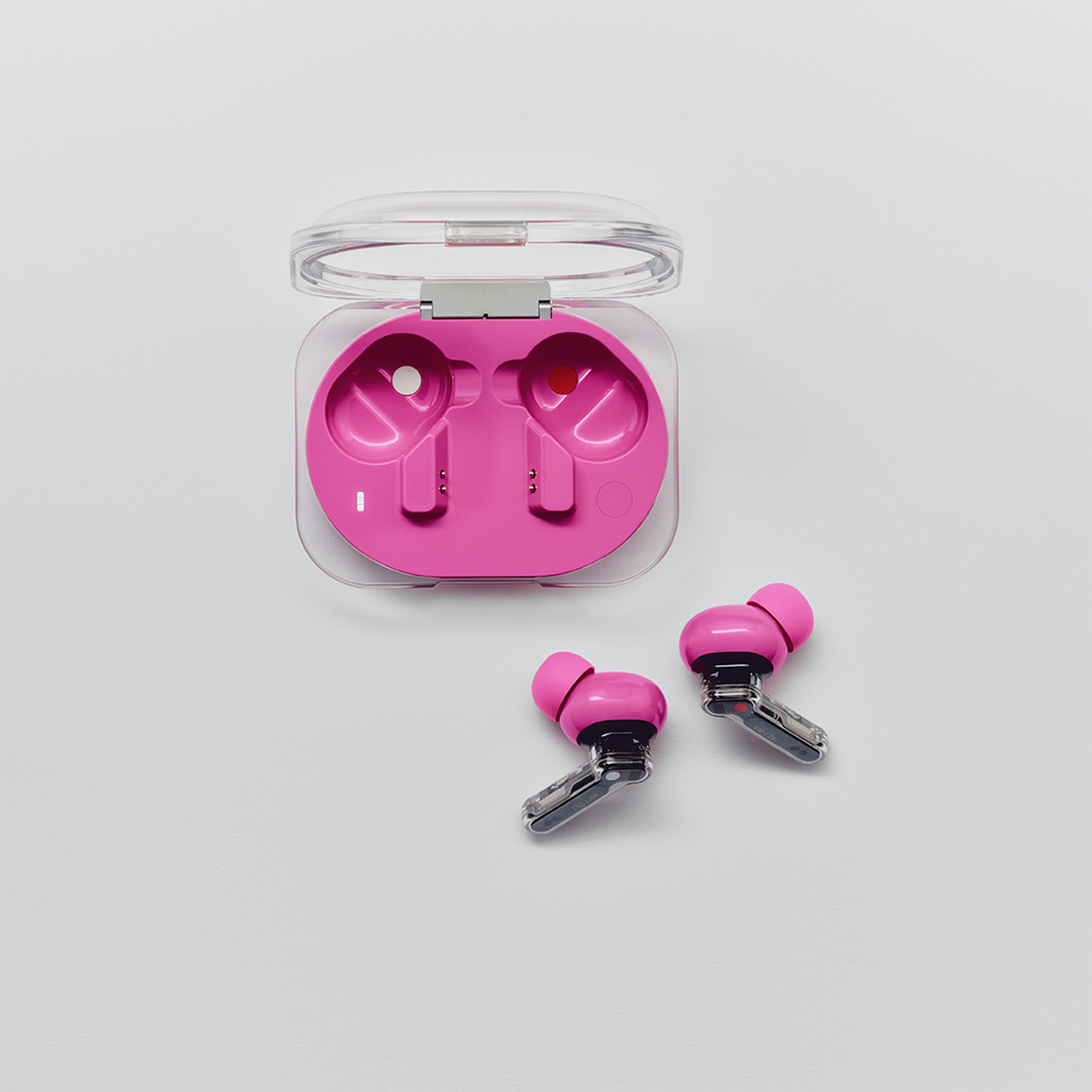 Auriculares inalámbricos rosas y su estuche transparente abierto sobre fondo blanco.