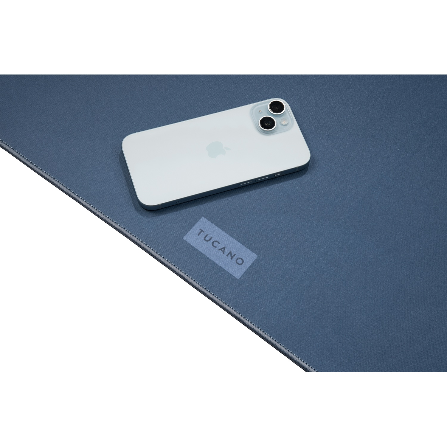 Uno smartphone azzurro giace su un tappetino blu con logo Tucano.