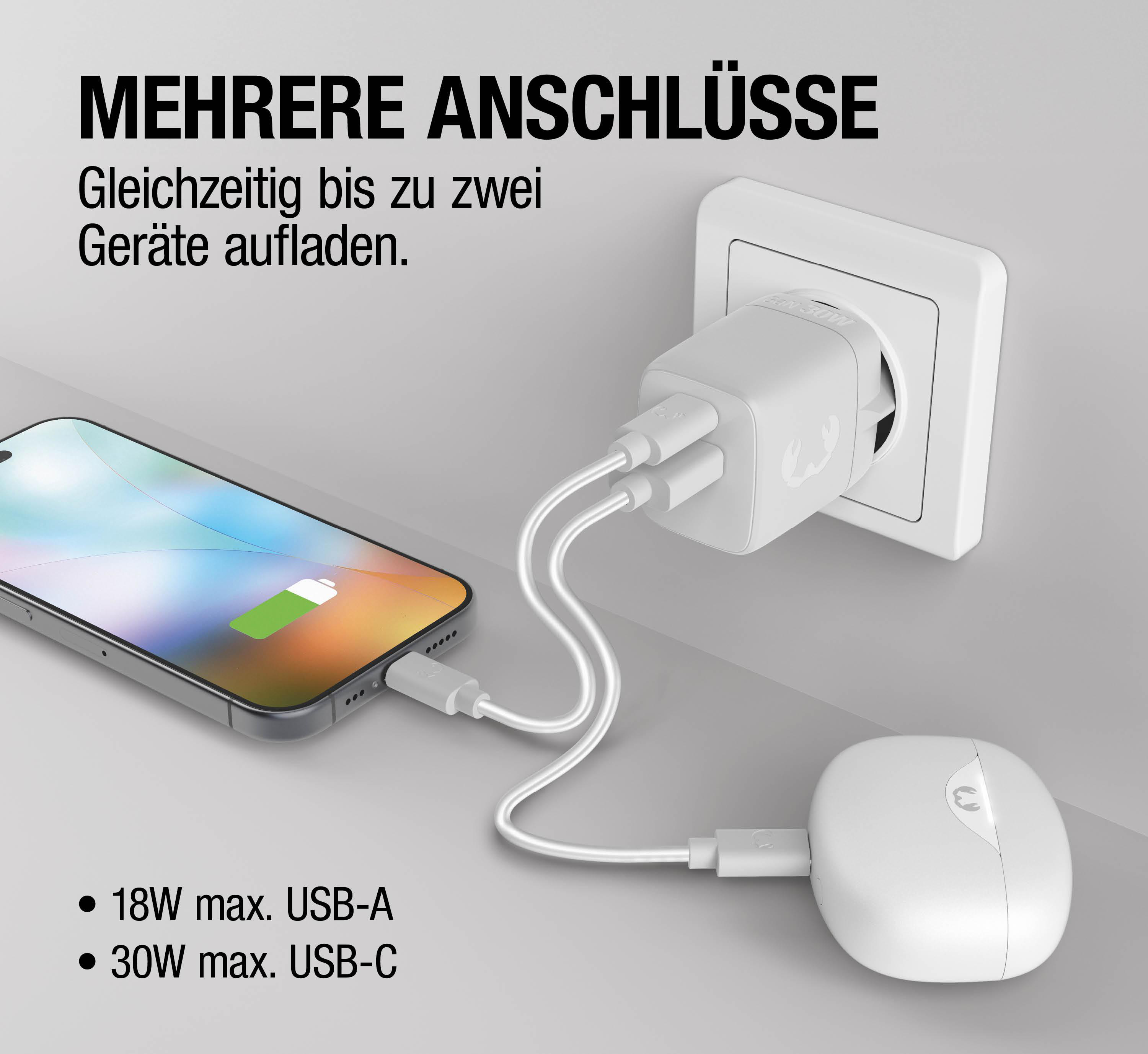 Ein weißer Netzstecker lädt ein Smartphone und ein kabelloses Ladegerät.