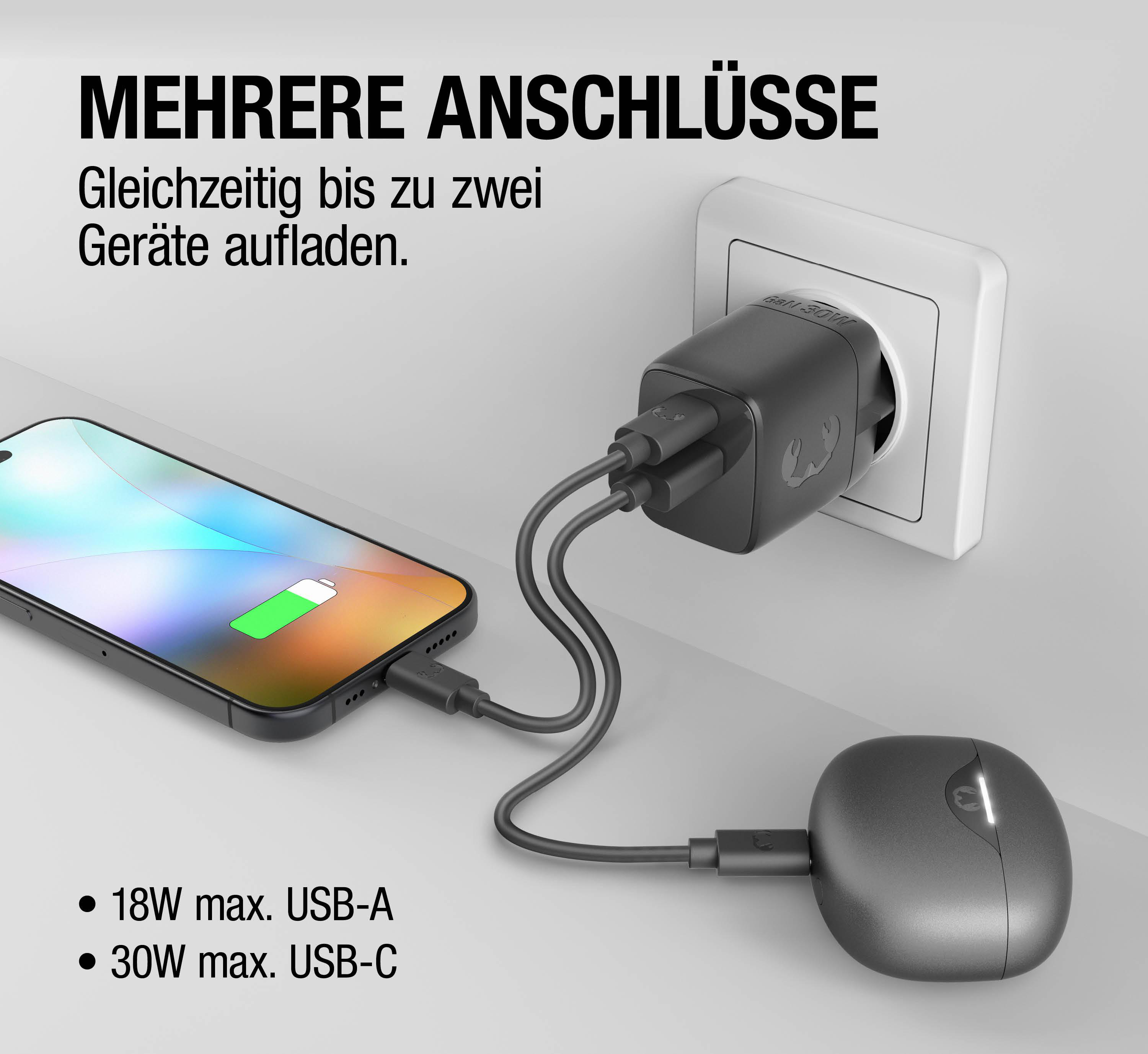 Ein schwarzer Ladestecker mit zwei Kabeln lädt ein Handy und eine Maus.