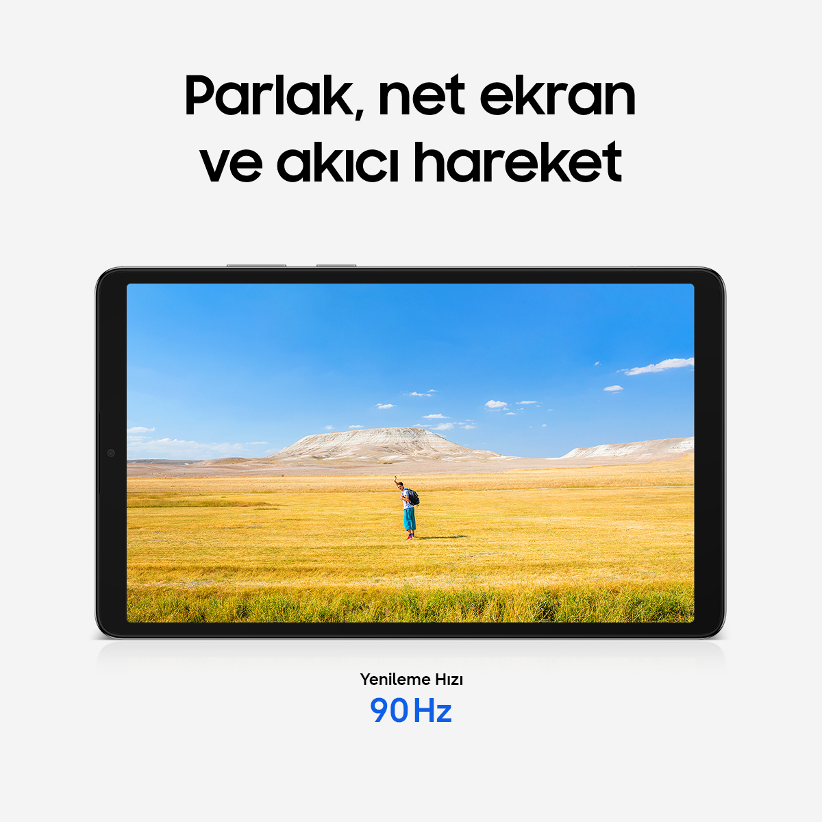Sırt çantalı bir adam mavi gökyüzü altında altın sarısı bir tarlada duruyor.