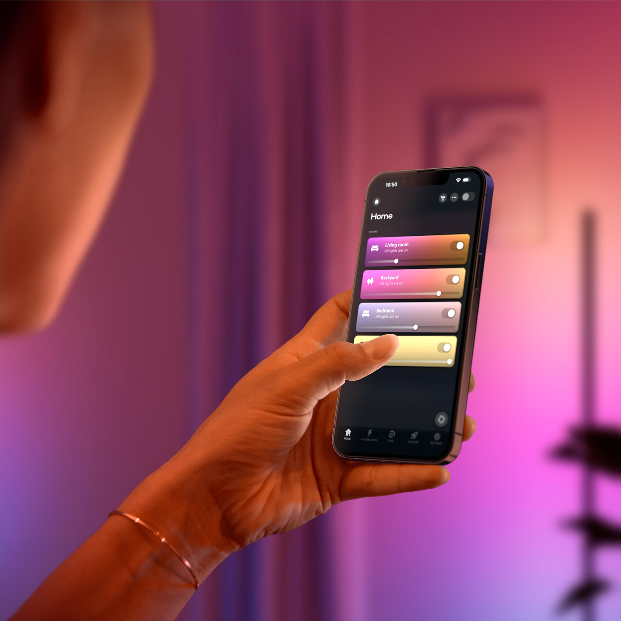 Eine Person hält ein Smartphone mit einer Smart-Home-App, die Lichter steuert.