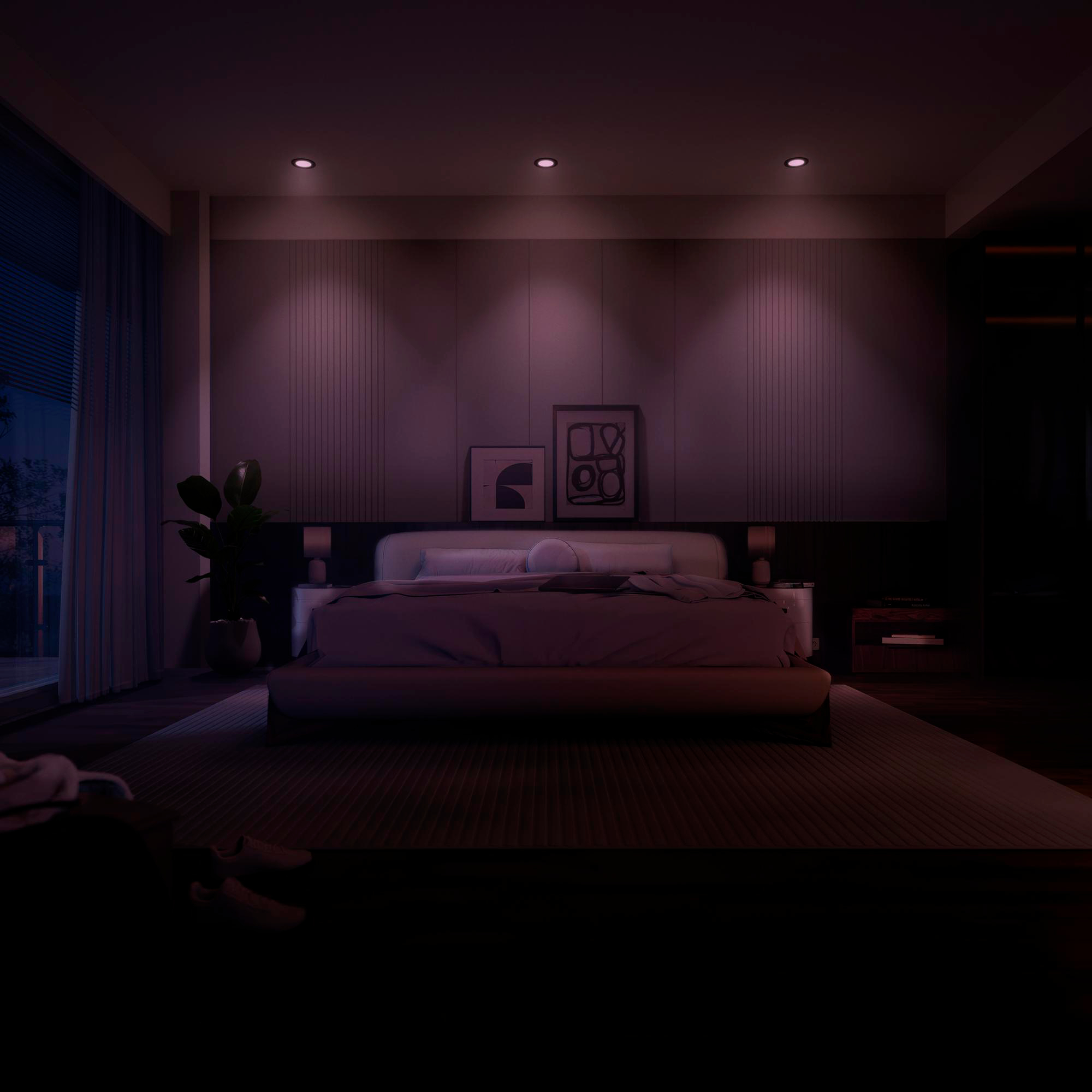 Ein dunkles Schlafzimmer mit einem großen Bett, Nachttischen und einem Fenster.
