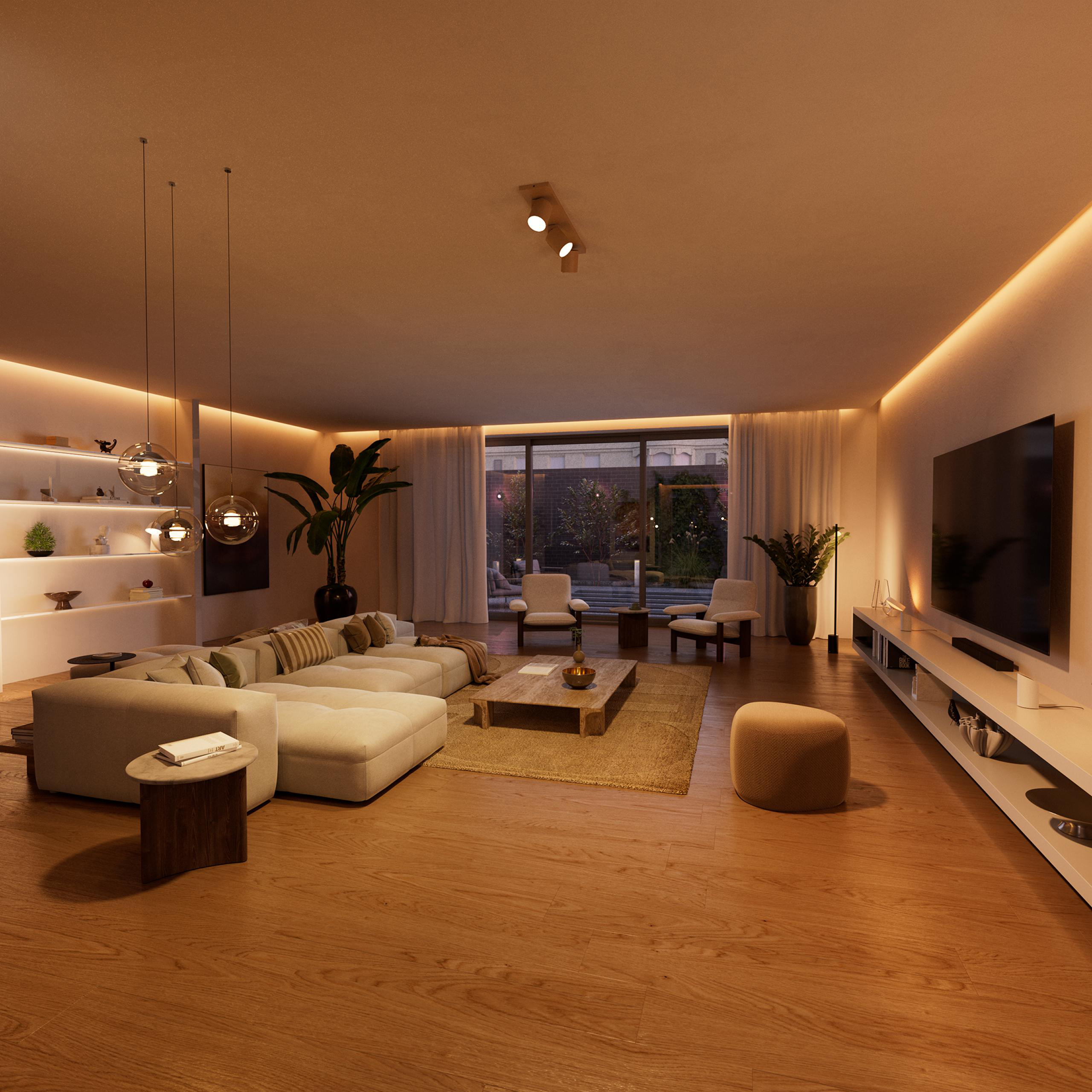 Ein großes, helles Wohnzimmer mit einem Ecksofa, Couchtisch, Fernseher und Terrassentür.