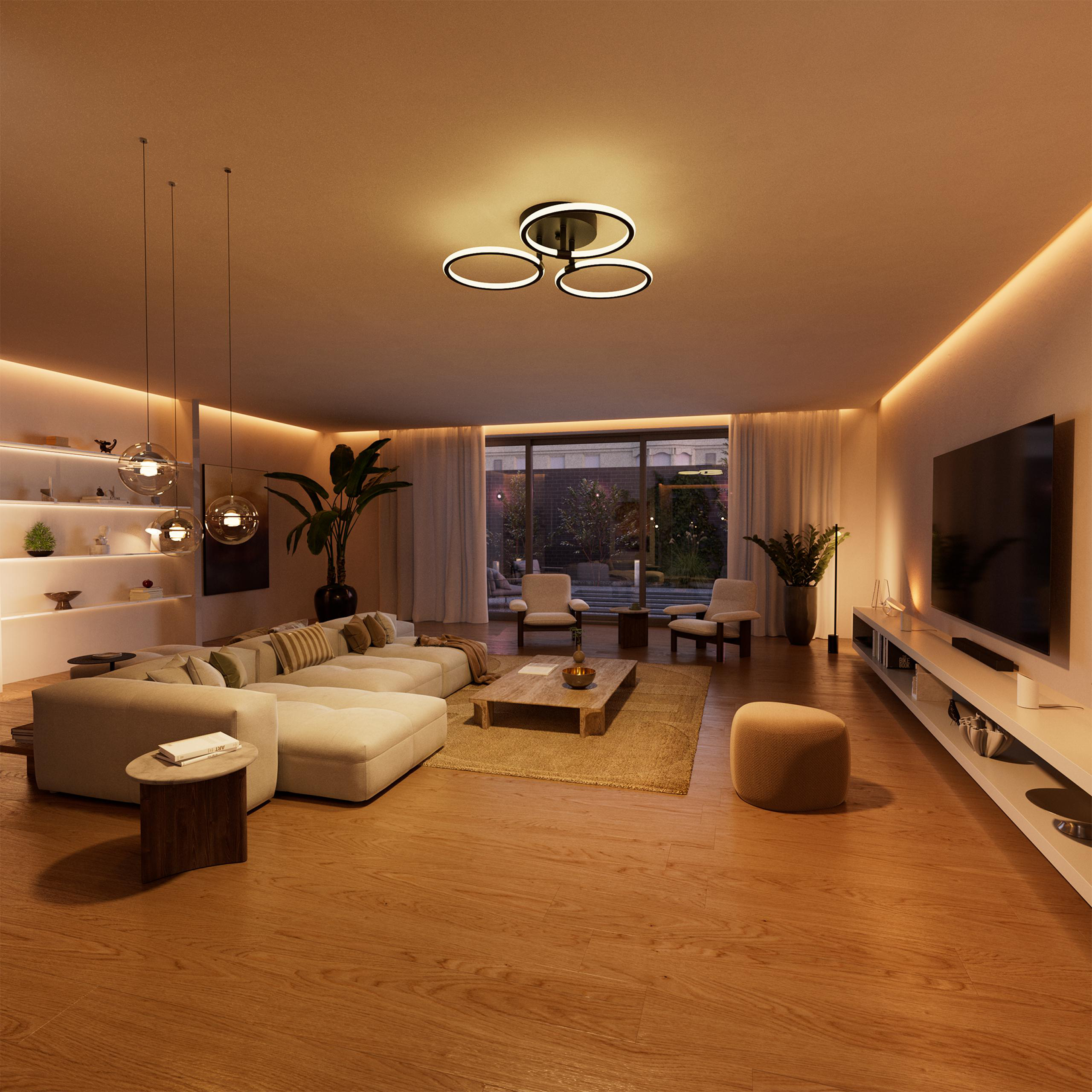 Ein modernes Wohnzimmer mit Ledersofa, Couchtisch und Fernseher.