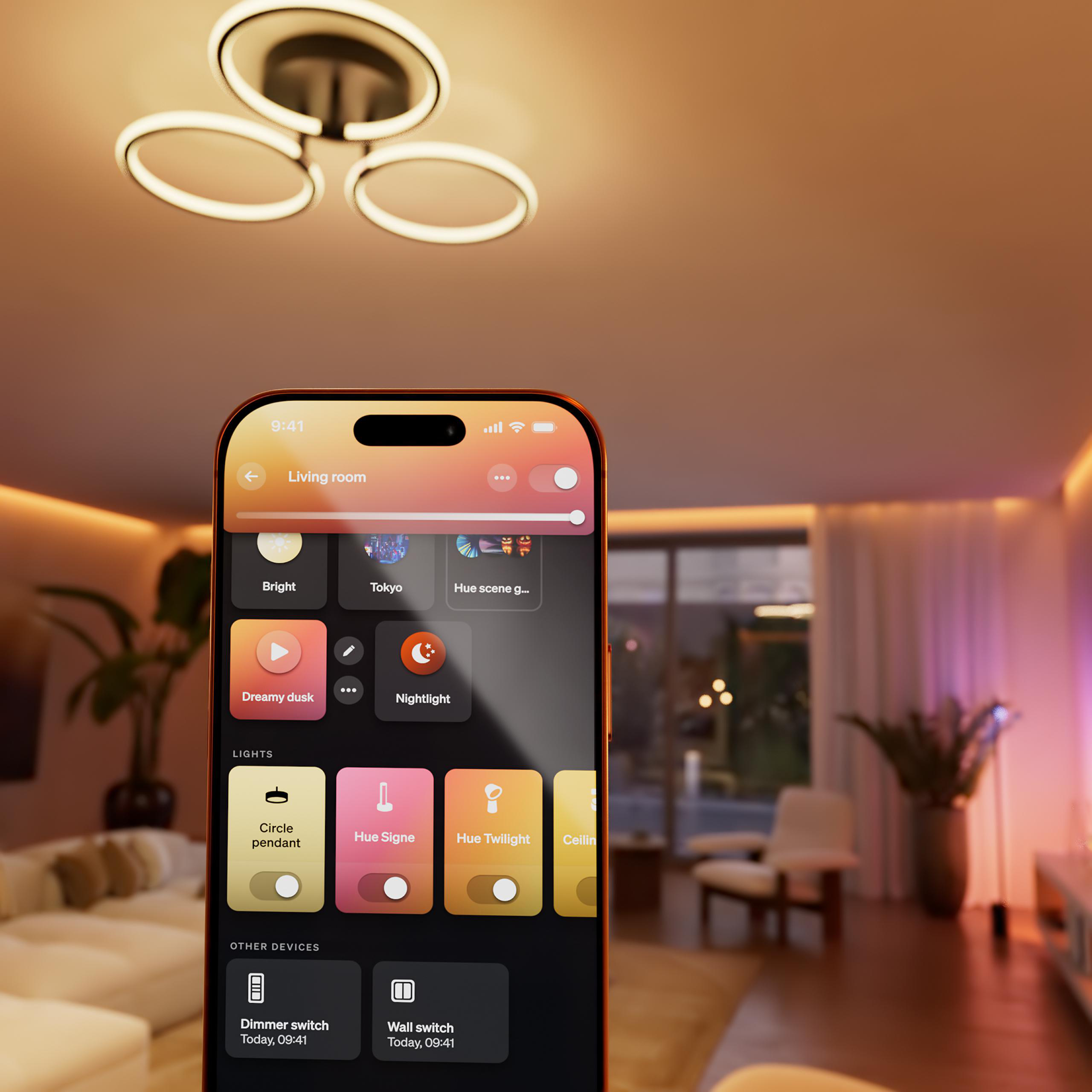 Ein Smartphone zeigt eine App zur Lichtsteuerung in einem Wohnzimmer mit Deckenleuchte.