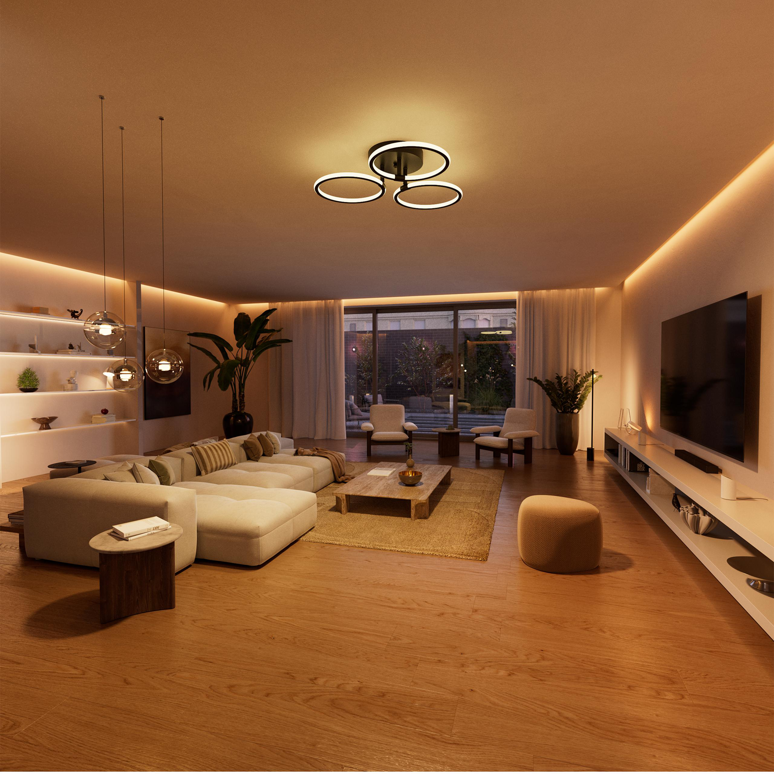 Ein gemütliches Wohnzimmer mit einem großen Ecksofa, Couchtisch und Fernseher.