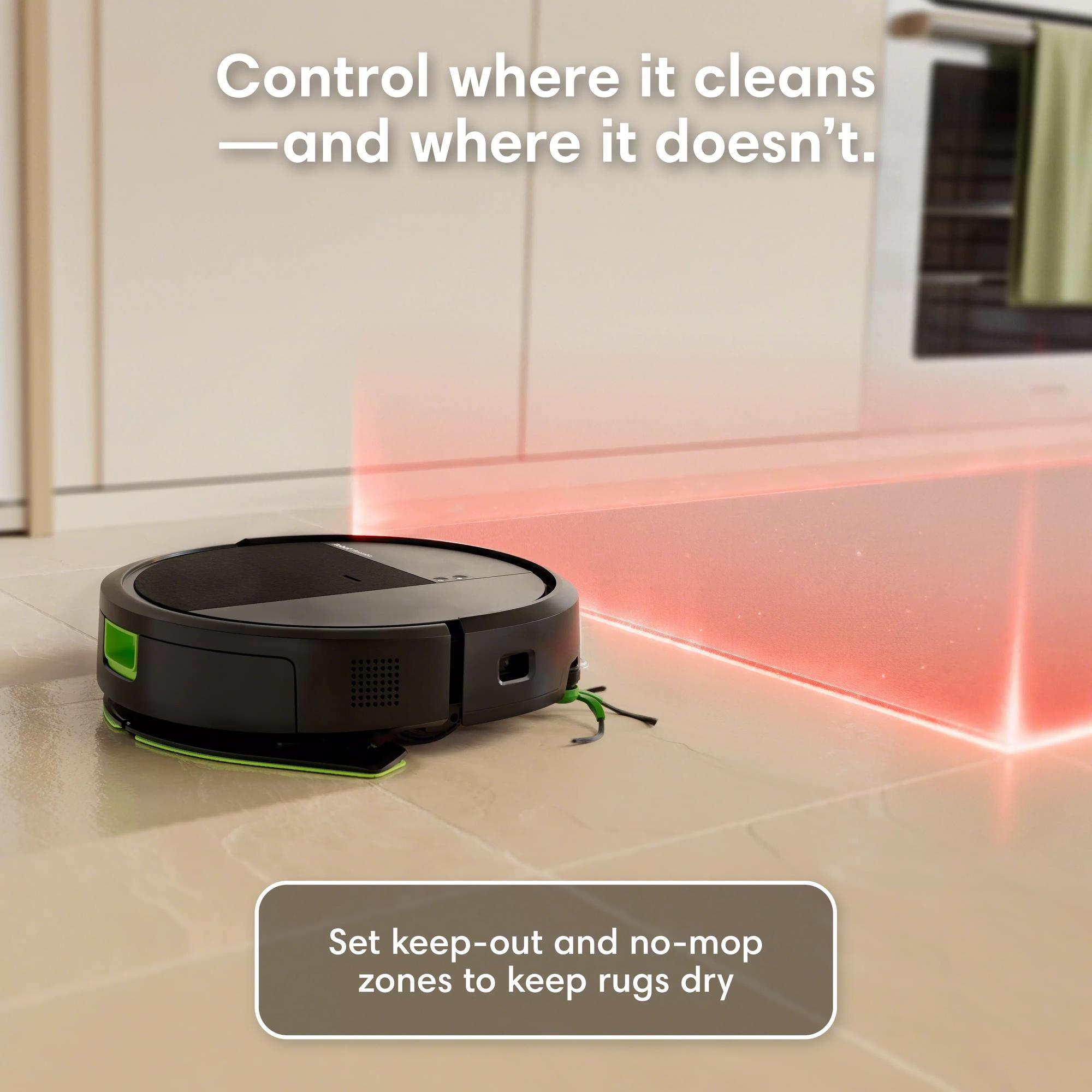 Un robot aspirateur noir avec des accents verts sur un sol clair, bordé de lumière rouge.