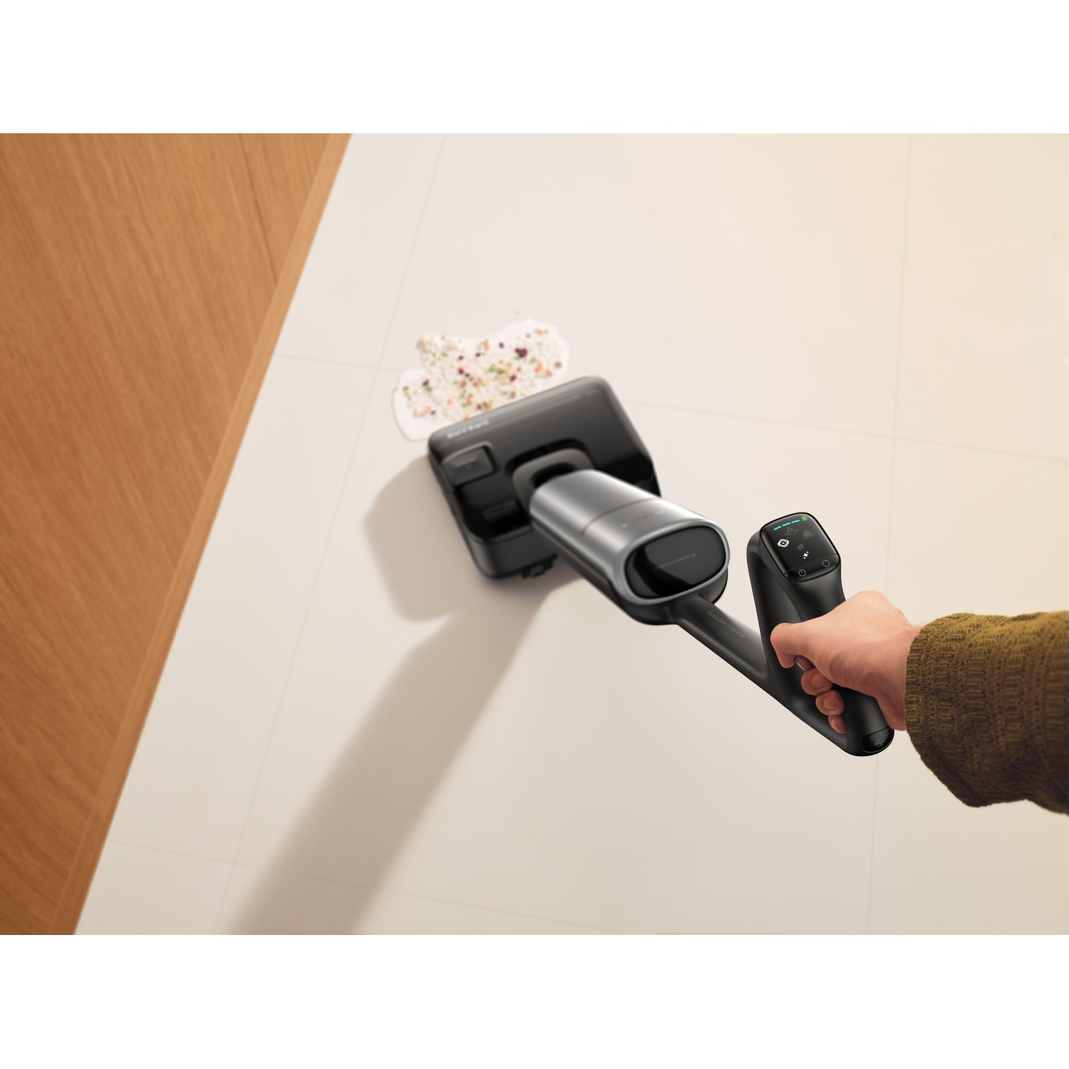 Hand vacuums spilled food on a light-colored floor.