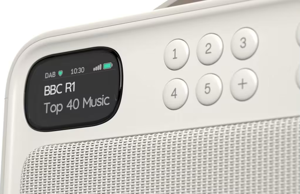 Une radio DAB blanche affiche BBC R1 Top 40 Music. Elle a des boutons numérotés.
