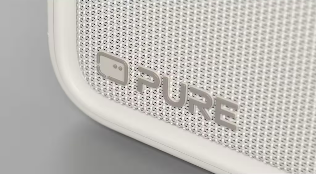 Une grille de haut-parleur blanche texturée avec le logo gris 'PURE' en relief.