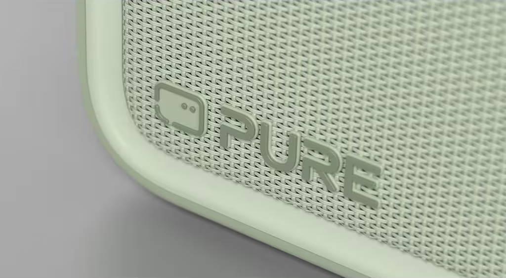 Gros plan d'un haut-parleur vert clair avec le logo "PURE".