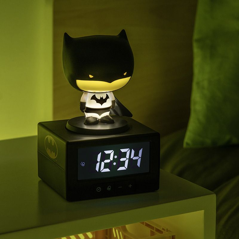 Batman éjszakai fényű ébresztőóra az éjjeli szekrényen. 12:34-et mutat.