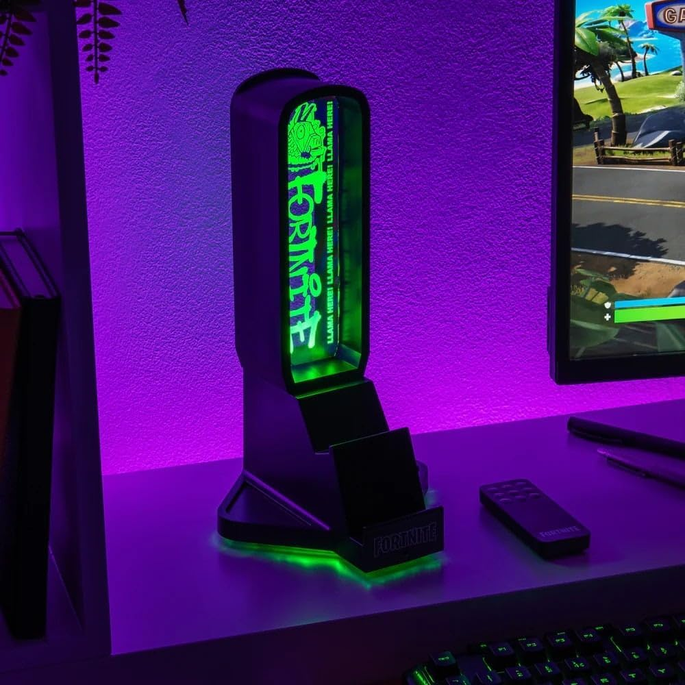Fekete Fortnite játéktartozék zöld neonfénnyel, monitoros íróasztalon.