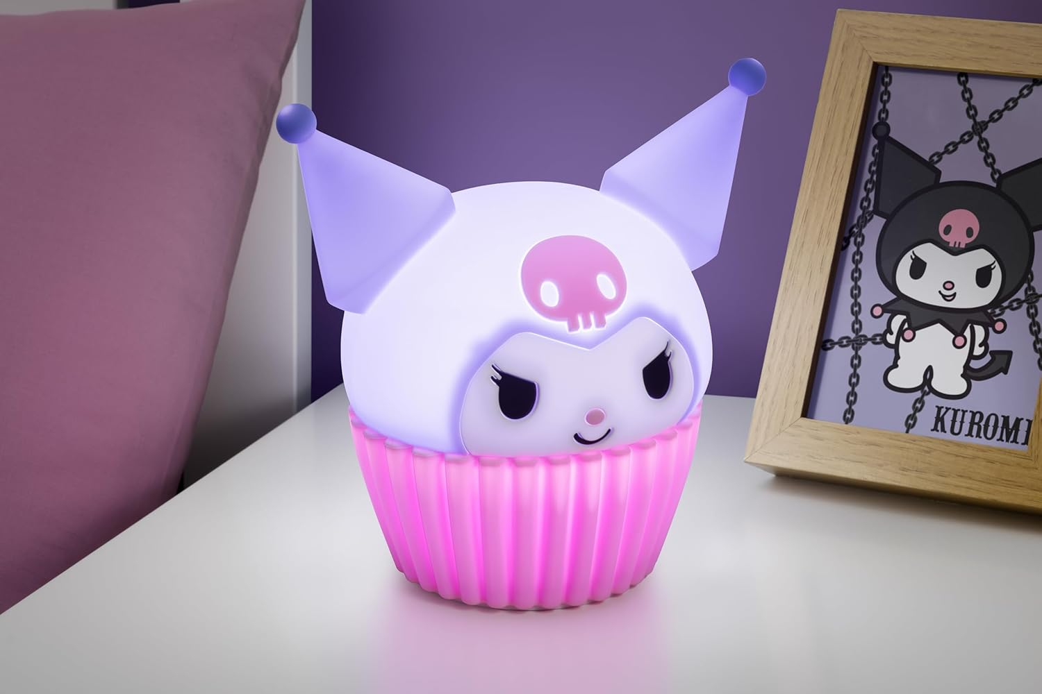 Egy világító, cupcake alakú Kuromi lámpa egy keretezett kép mellett.