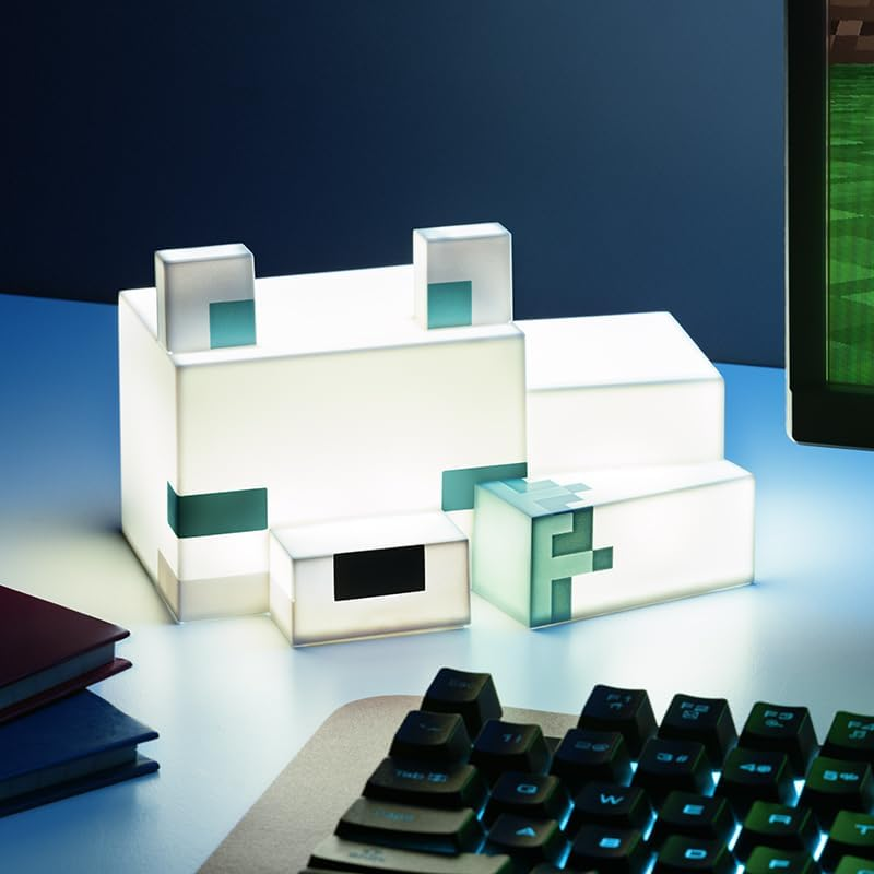 Egy világító Minecraft farkaskocka ül az asztalon, billentyűzet és könyvek mellett.