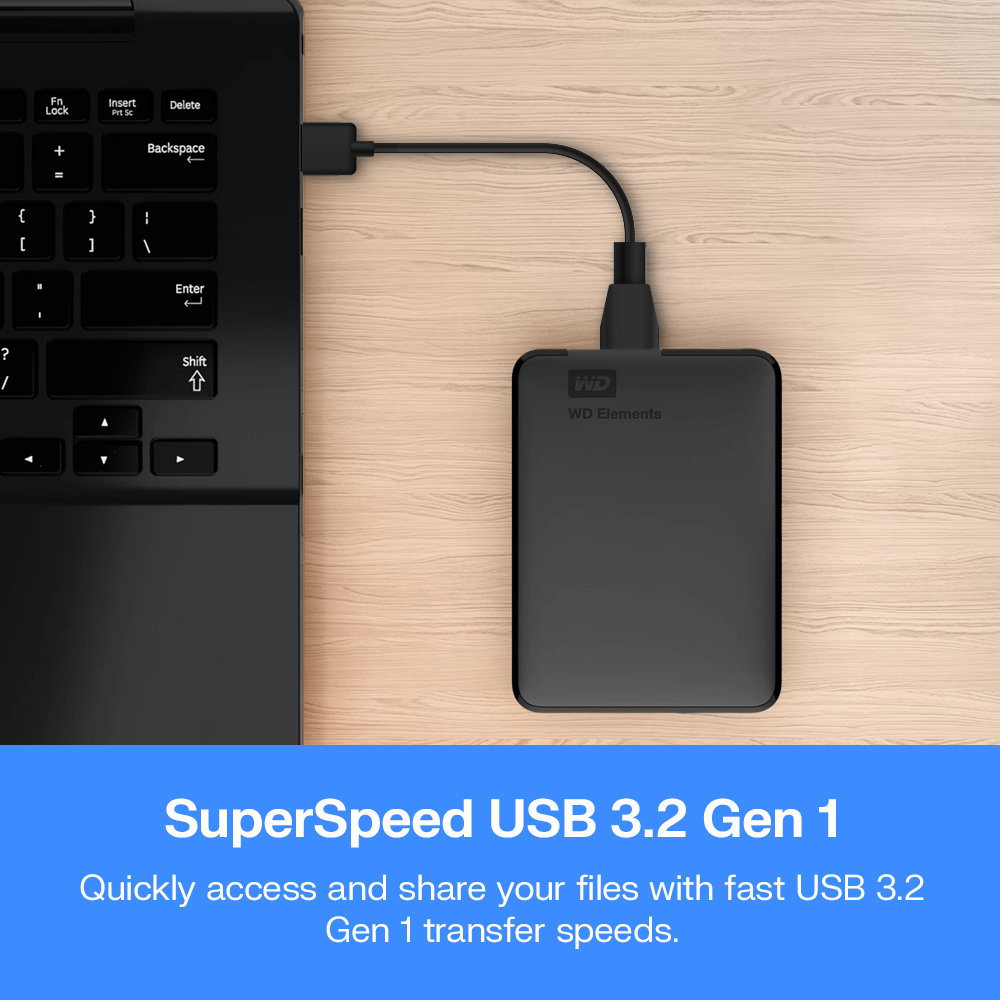 Hard disk esterno nero con logo WD collegato a un laptop su scrivania in legno.