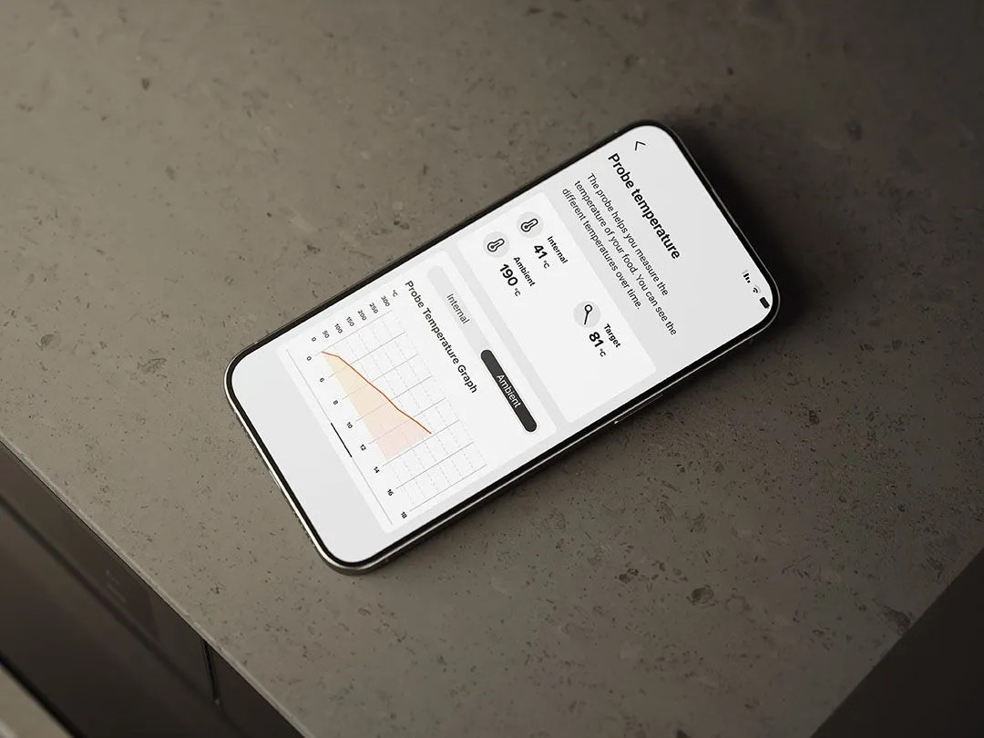 Smartfon wyświetla aplikację do pomiaru temperatury z wykresami i wartościami.