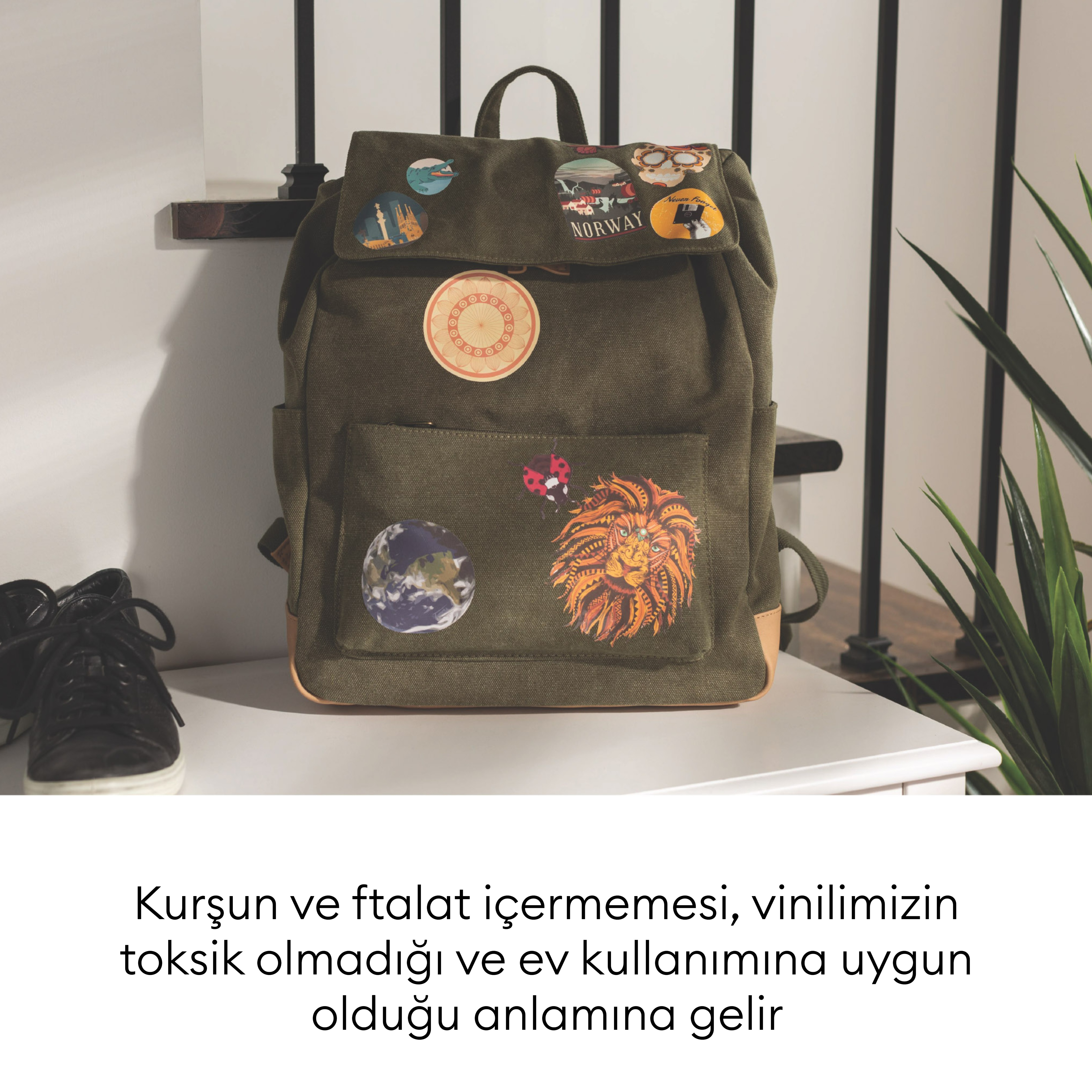 Norveç, Dünya ve aslan başı çıkartmalarıyla süslenmiş yeşil sırt çantası.