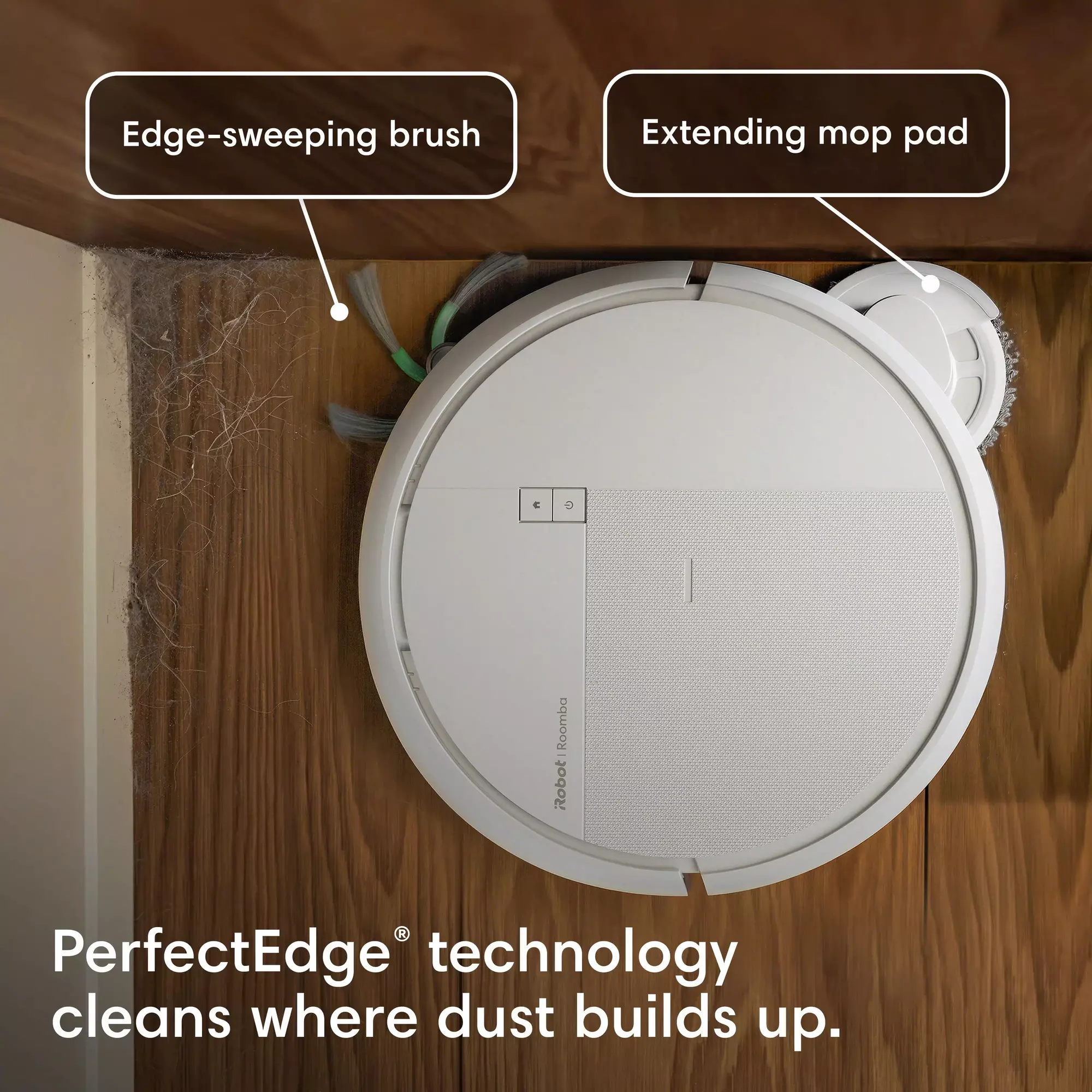Un aspirateur robot blanc nettoie un coin poussiéreux aux murs et au sol en bois.
