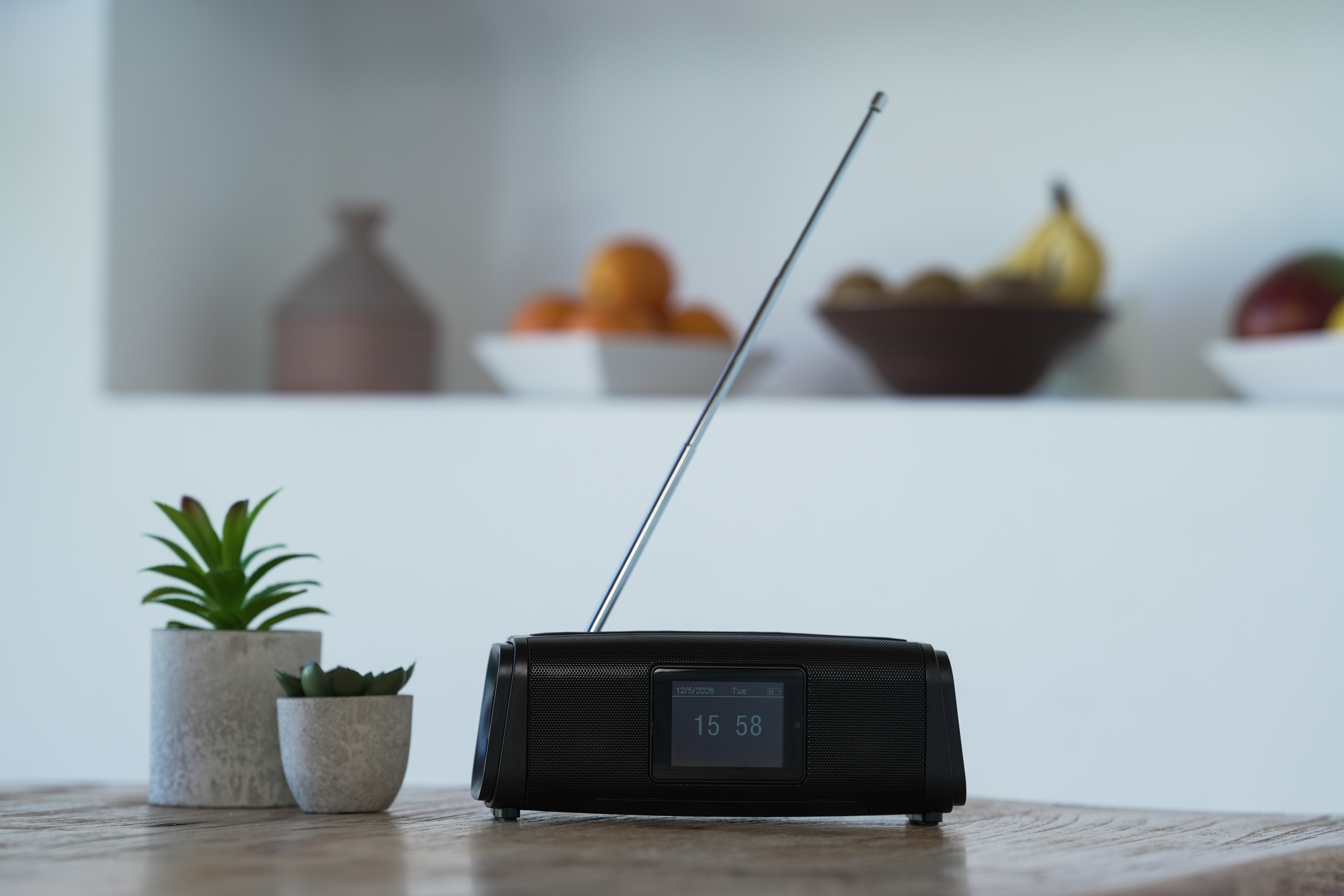 Czarno-radio z wysuniętą anteną na drewnianym stole.