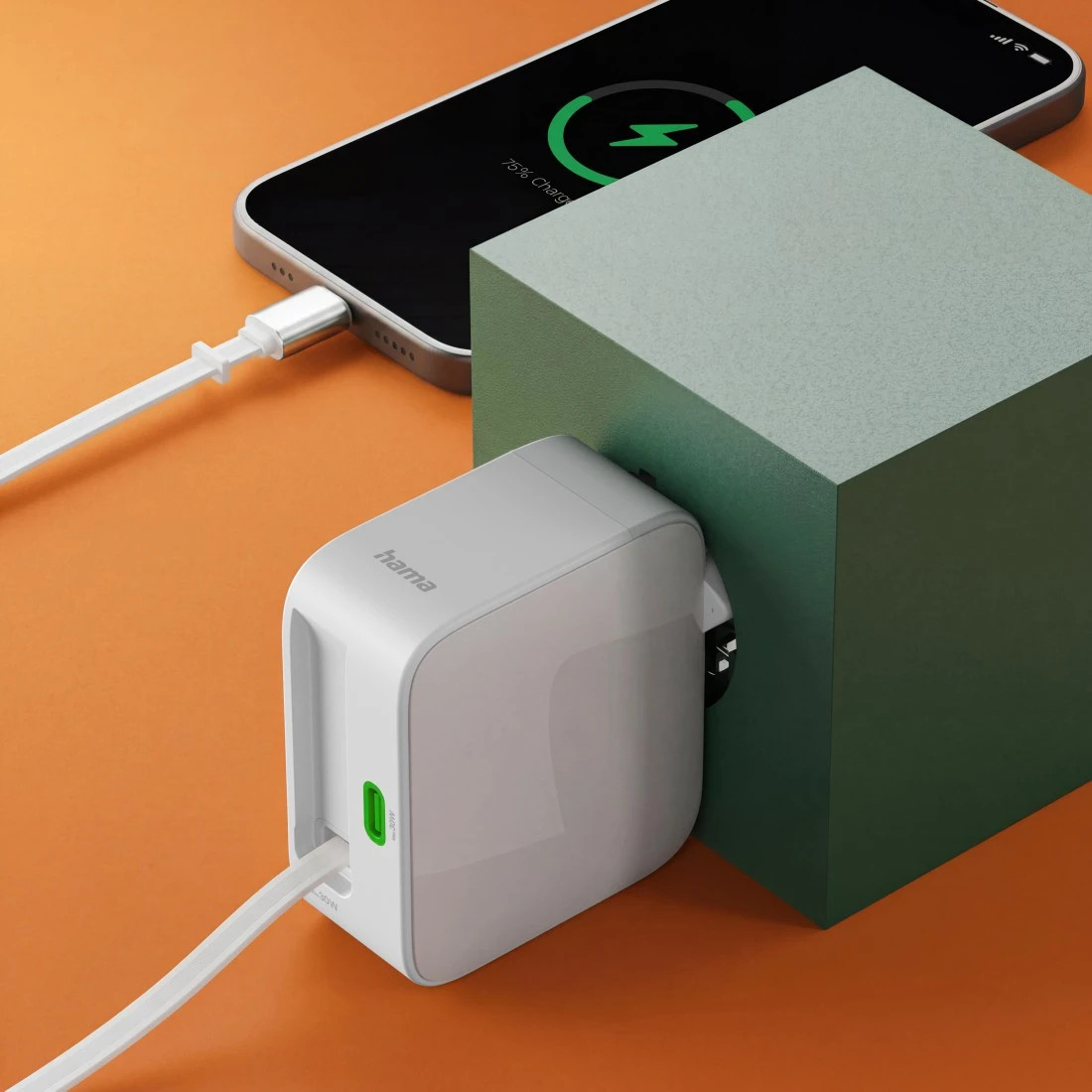 Biała ładowarka zasila smartfon podłączony do zielonego sześcianu.