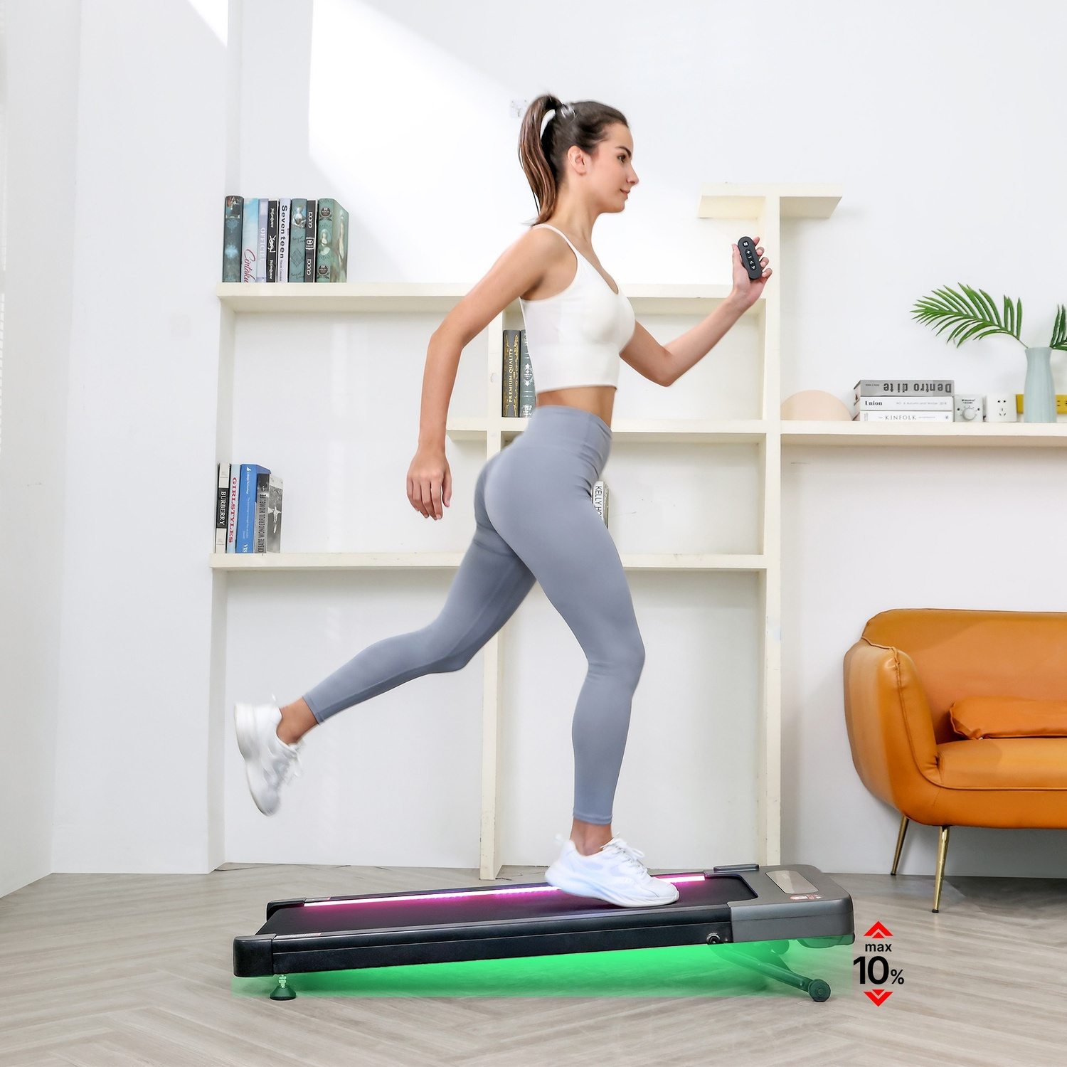 Donna corre su tapis roulant con telecomando. Stanza con scaffali e divano.
