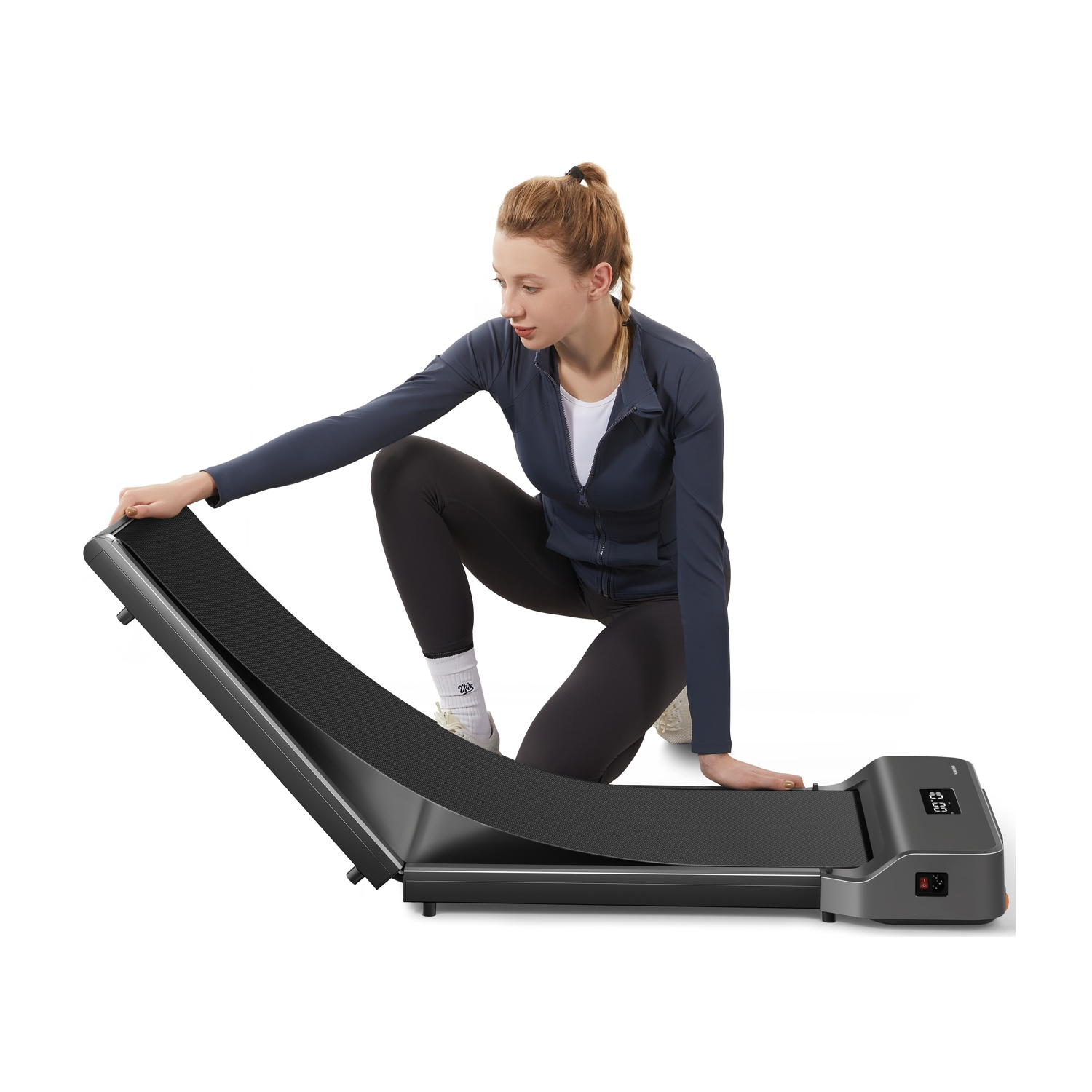 Una donna in abbigliamento sportivo si inginocchia su un tapis roulant, toccando il nastro.