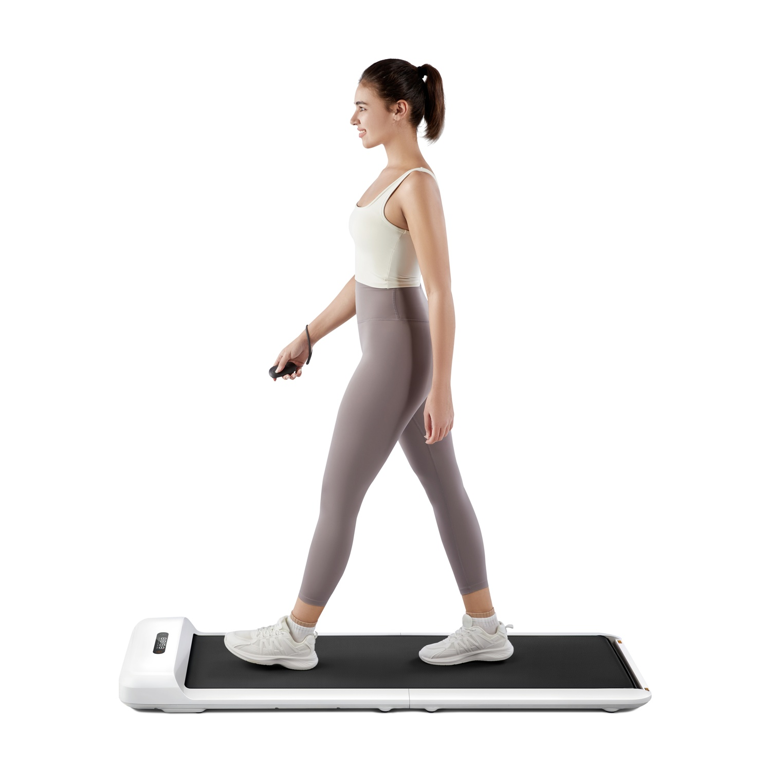 Una donna in abbigliamento sportivo cammina su un tapis roulant bianco con nastro nero.
