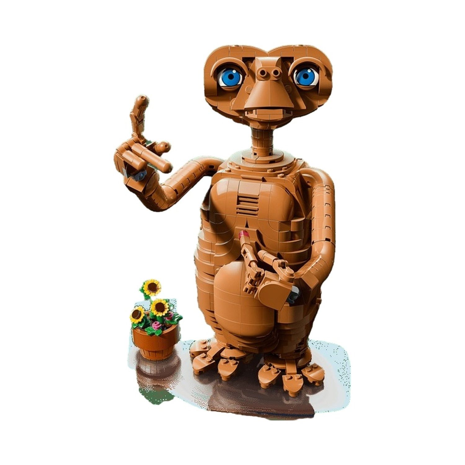 Una figura Lego marrone di E.T. con occhi blu accanto a un vaso di girasoli.