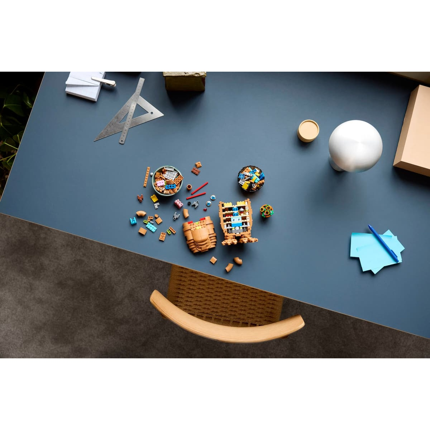 Una scrivania con mattoncini Lego, un righello e carta per appunti.