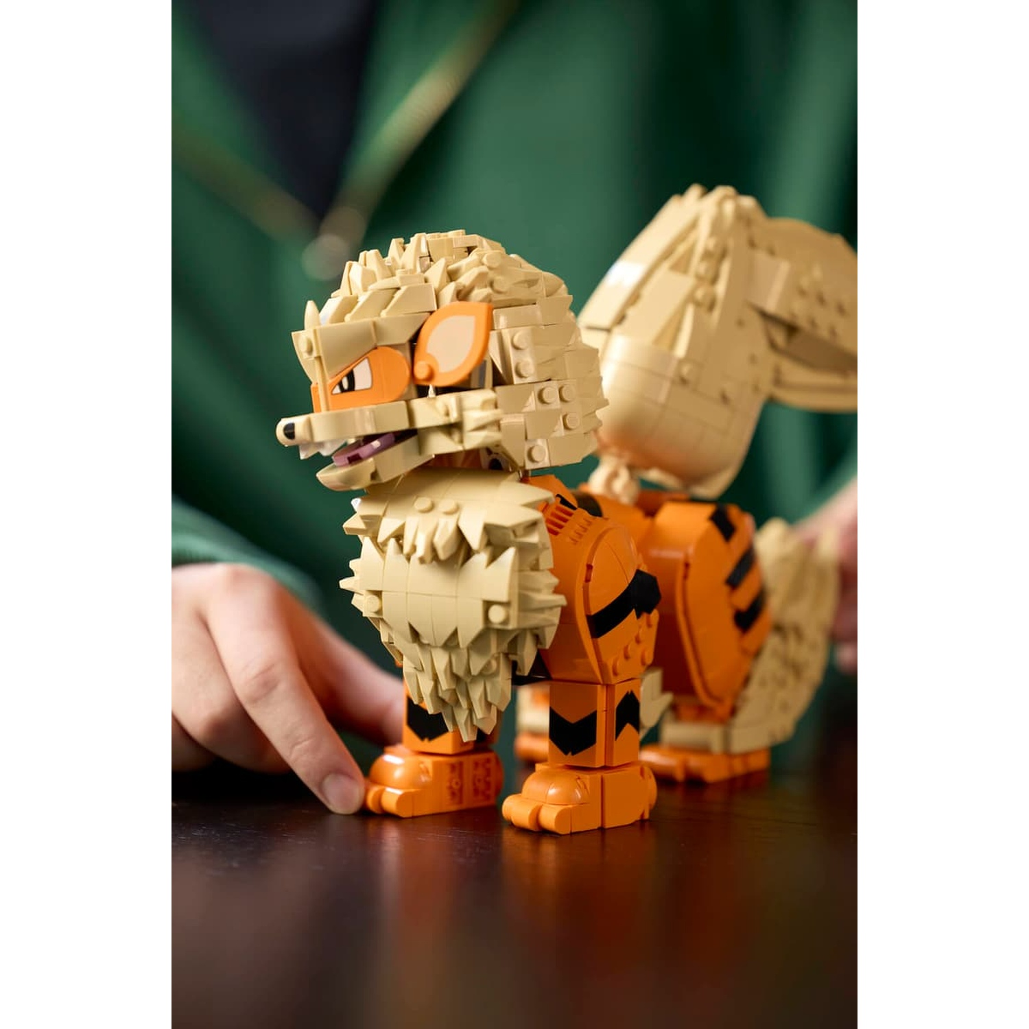 Un modello Lego di cane con pelliccia beige e arancione si trova su un tavolo.
