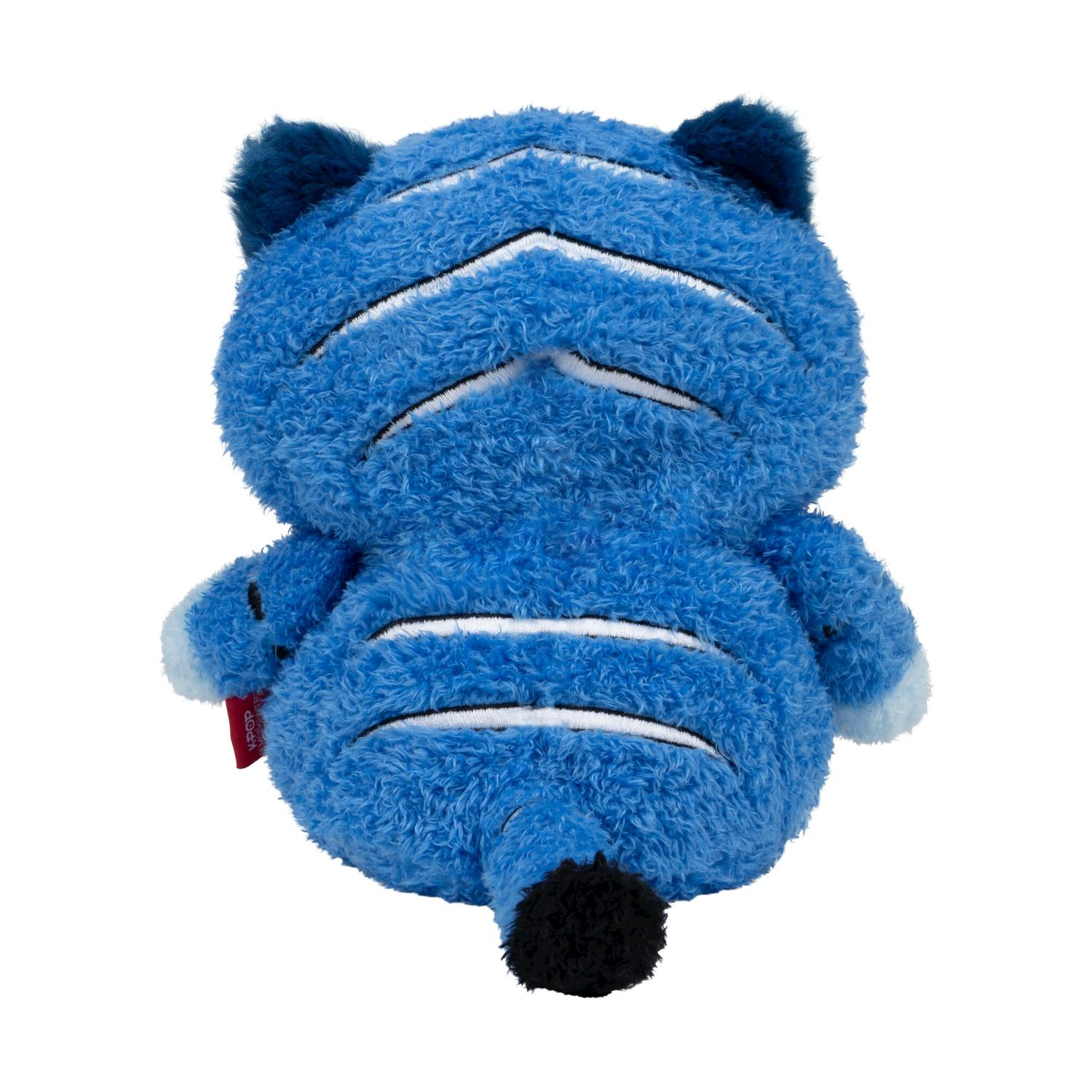Una tigre di peluche blu con strisce bianche è seduta, la coda è nera.
