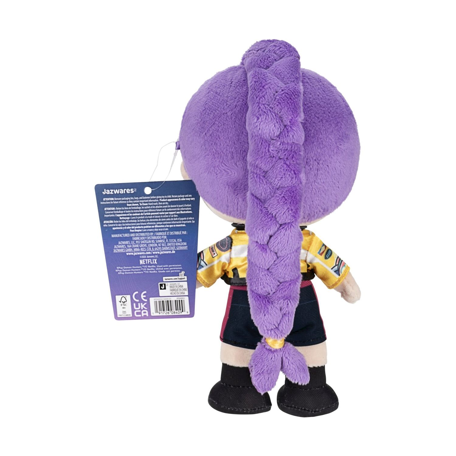 Peluche con treccia viola, giacca gialla e pantaloncini neri, visto da dietro.