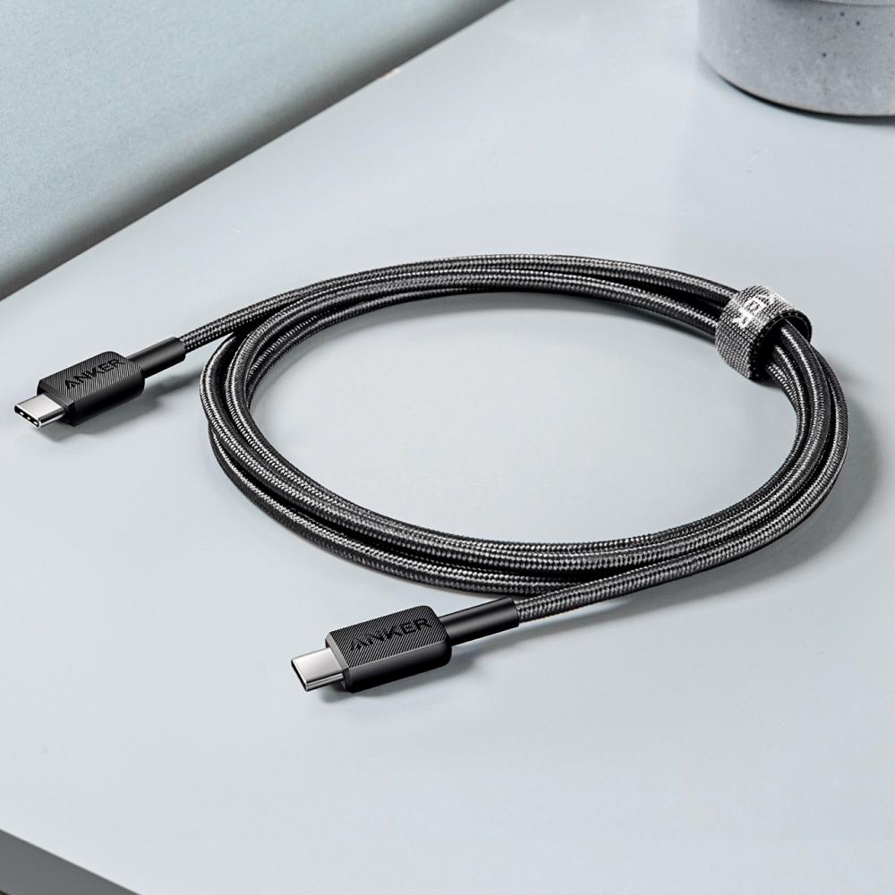 Ein graues USB-C-Kabel mit Anker-Logo liegt auf einer grauen Oberfläche.