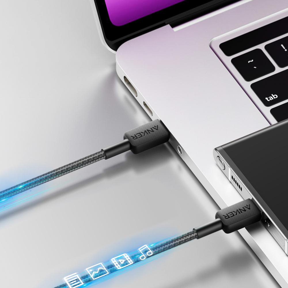 Anker-Kabel verbinden Laptop und Smartphone, mit blauen Lichteffekten.