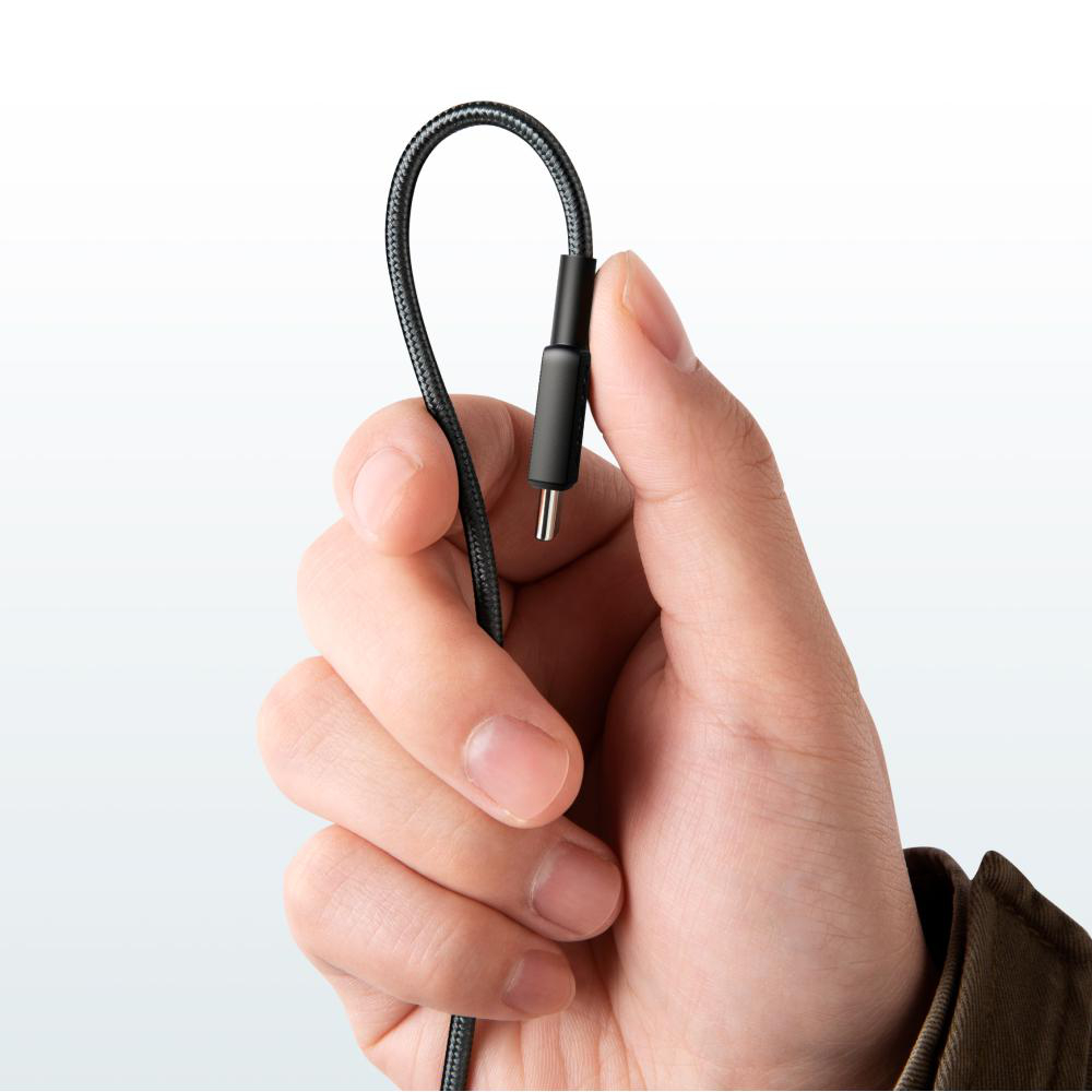 Eine Hand hält ein schwarzes USB-C-Kabel mit einem Stecker.