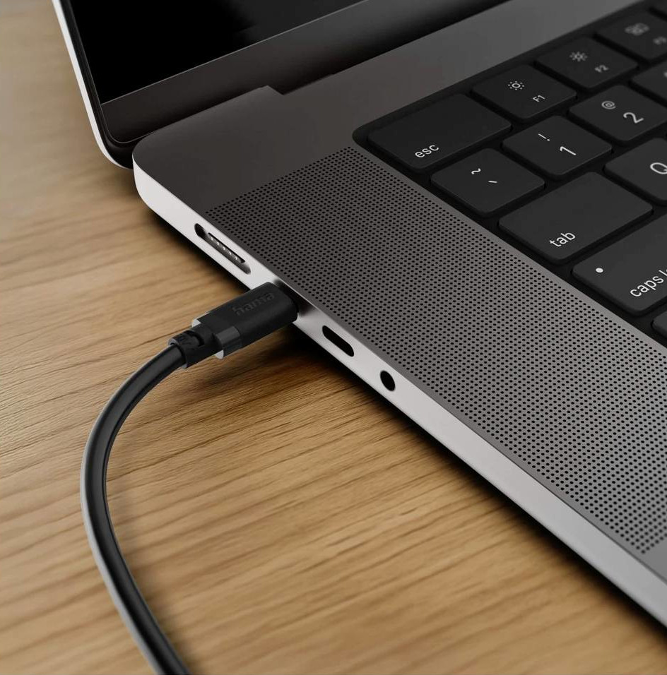 Czarny kabel USB-C podłączony do szarego laptopa na drewnianym biurku.