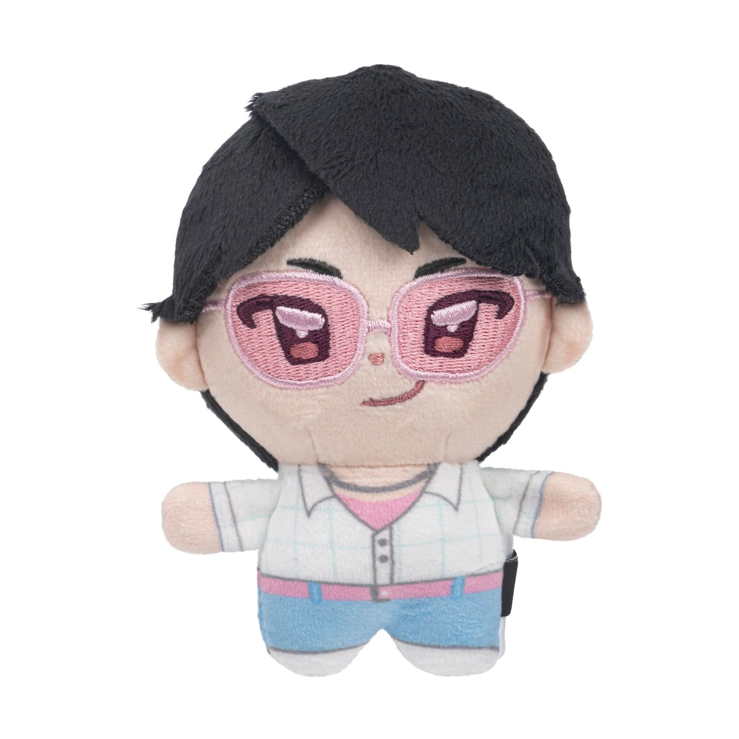 Peluche con capelli scuri, occhiali rosa, camicia bianca e pantaloncini blu.
