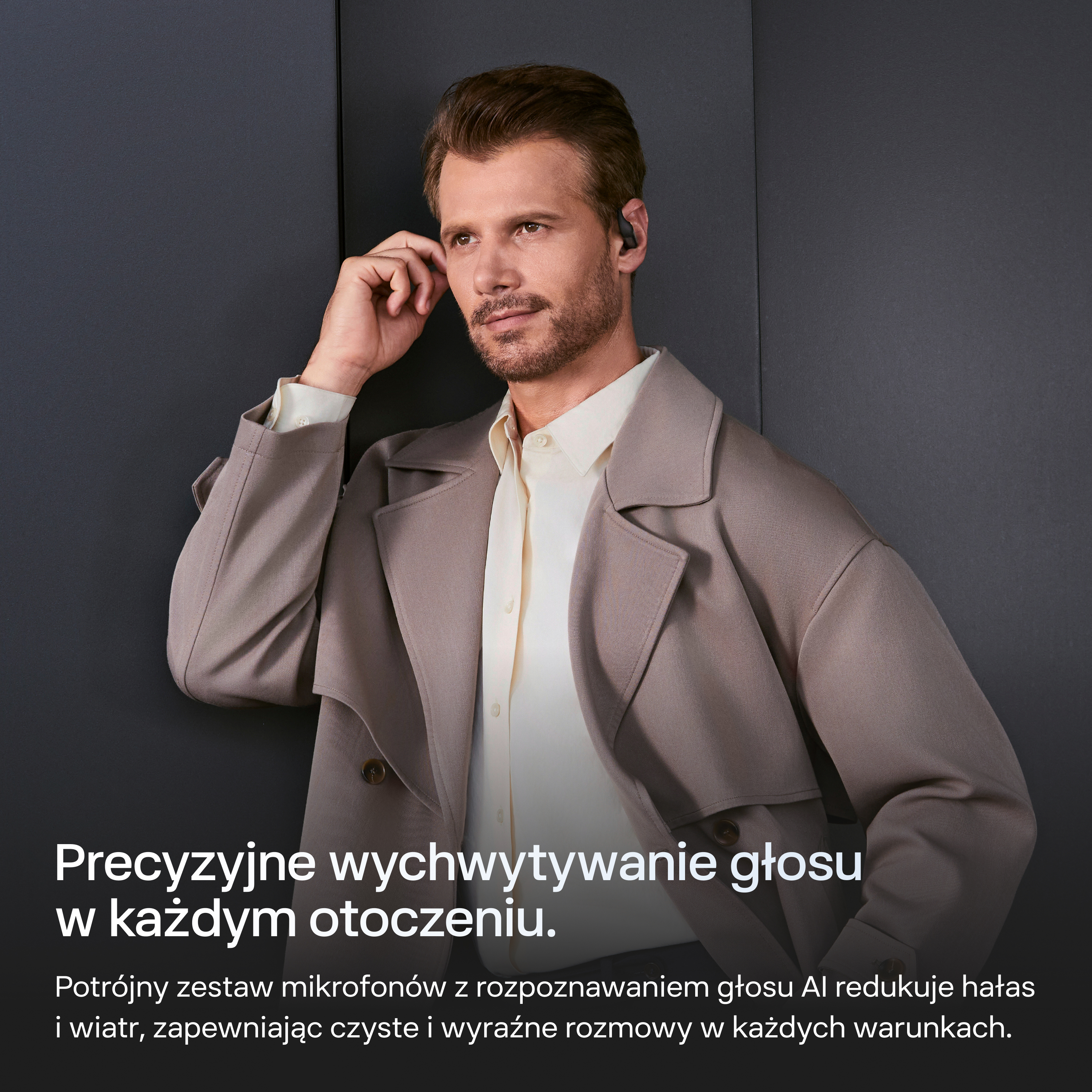 Mężczyzna w słuchawkach, beżowym płaszczu i jasnej koszuli.