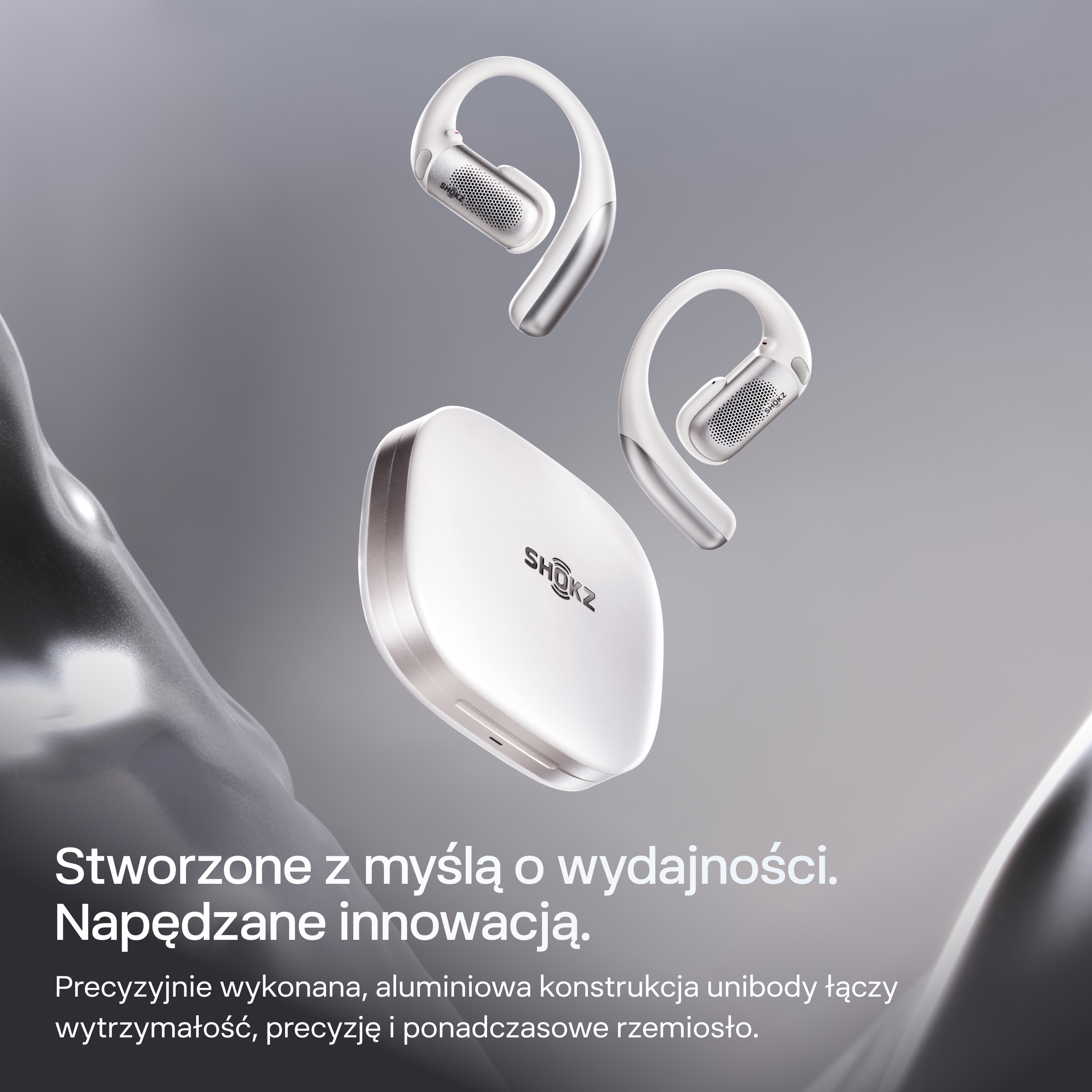 Białe słuchawki SHOKZ i etui ładujące na szarym tle.