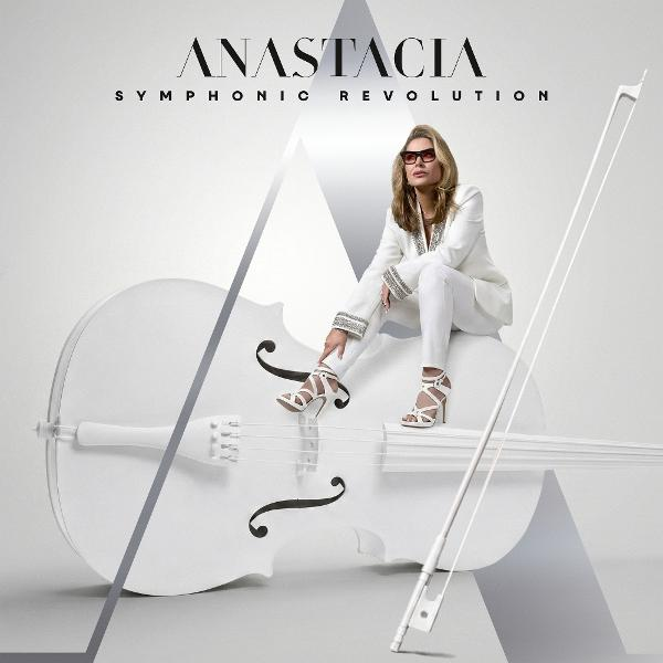 Anastacia sitzt auf einem weißen Cello, trägt weiße Kleidung und Sonnenbrille.